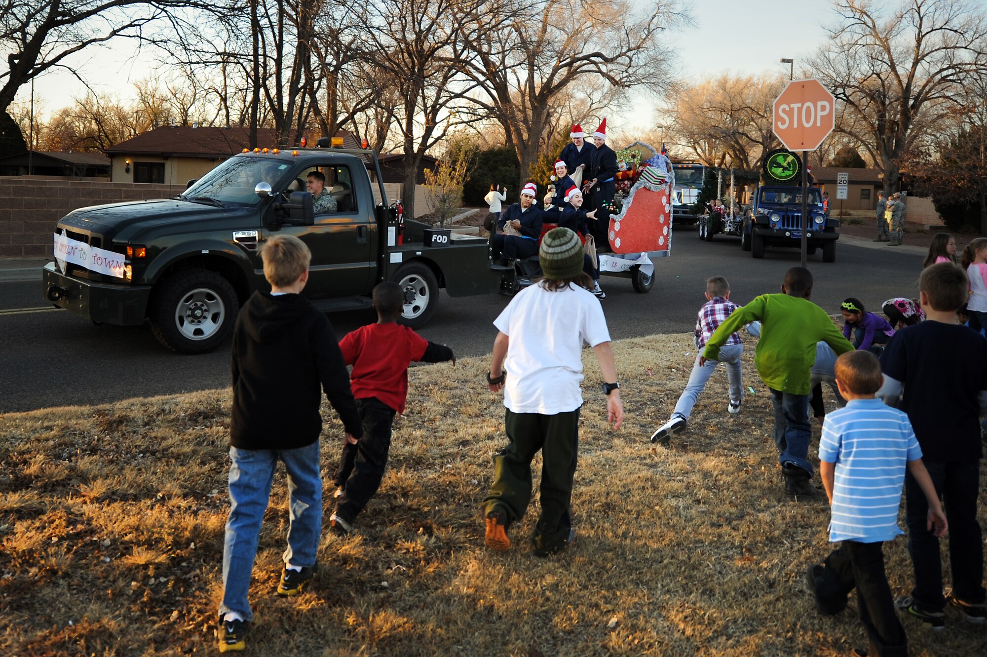 Children run for candy as a float passes during the annual holiday parade and tree lighting ceremony at Cannon Air Force Base, N.M., Nov. 29, 2012.  This festive event takes place each year as a kick-off to the holiday season.  (U.S. Air Force photo/Senior Airman Jette Carr)