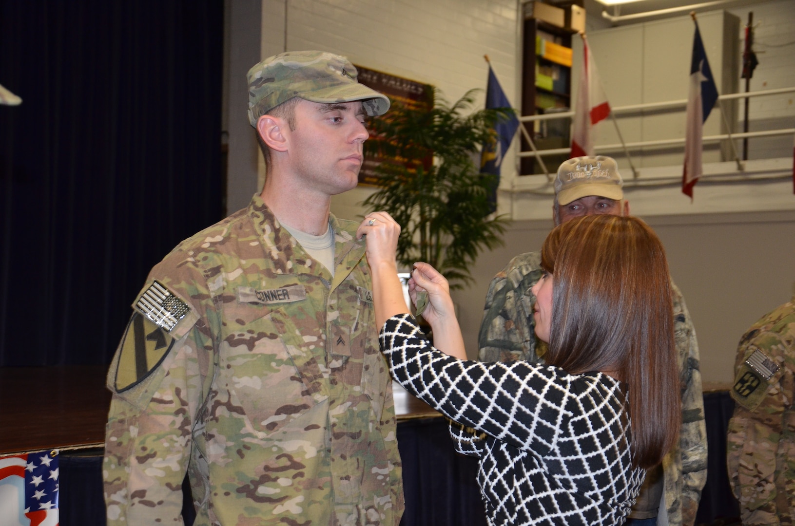 Sara Conner pins the rank of sergeant on her husband, Cpl. Christopher Conner Nov. 19 after the 440th Blood Support Detachment welcome home ceremony at Roadrunner Community Center on Joint  Base San Antonio-Fort Sam Houston. (Photo by Lori Newman, JBSA-Fort Sam Houston Public Affairs)