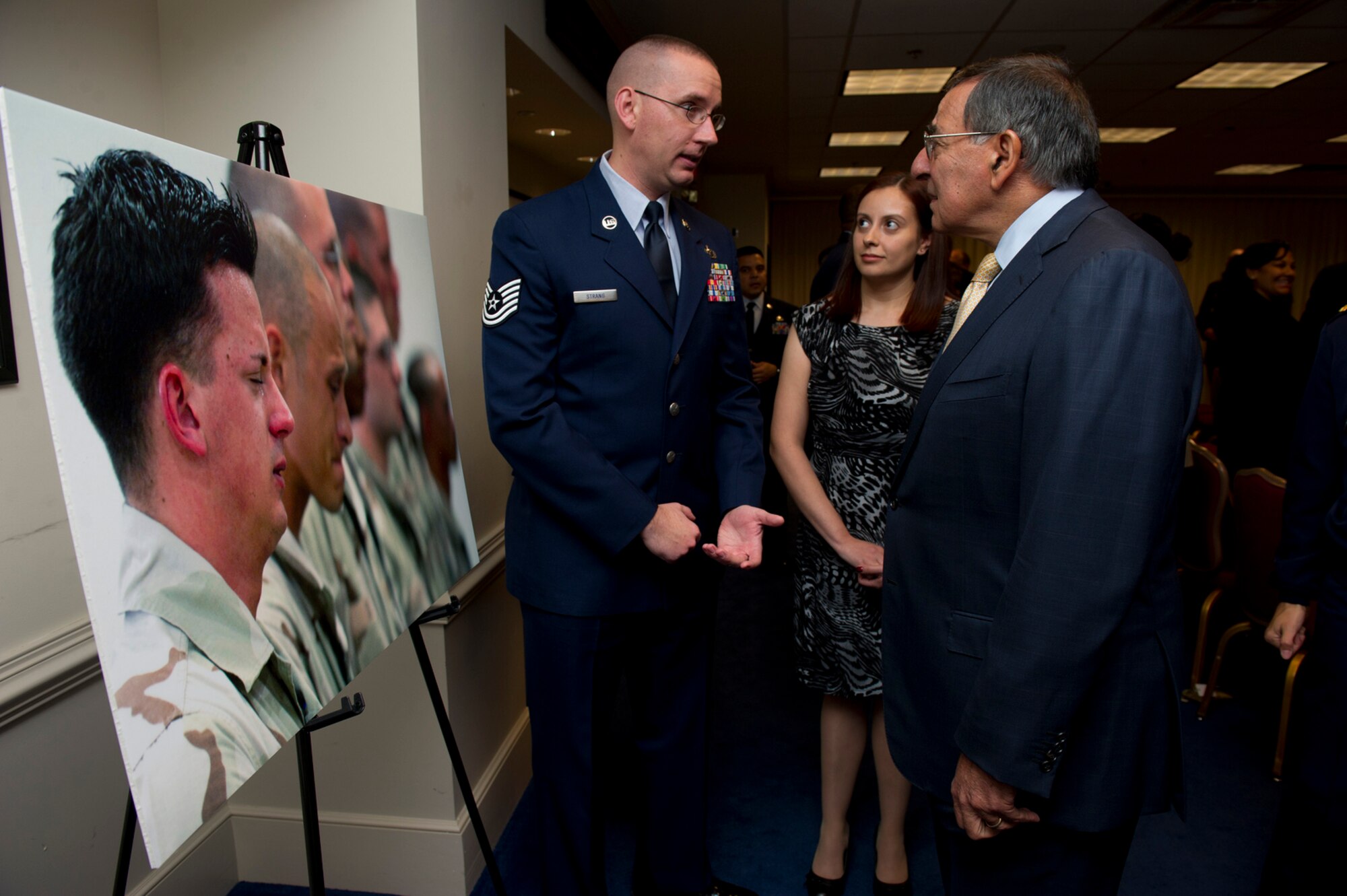 Secretary of Defense Leon E. Panetta, right,  speaks Tech. Sgt. Joshua Strang about Strang's award-winning photograph at the Art in Embassies best in show awards ceremony at the Pentagon, Nov 30, 2012. Strang is an instructor at the Defense Information School at Ft. Meade, Md. (DOD phoo/Erin A. Kirk-Cuomo)
