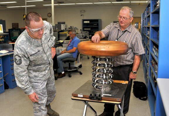 Master Sgt. Lars Mirandamuller, AEDC PMEL/Chemical Laboratories section chief, and Dave Compton, Aerospace Testing Alliance (ATA) PMEL manager, examine a high voltage divider during a recent inspection held annually at one of the most unique calibration labs in the world. (Photo by Jacqueline Cowan)
