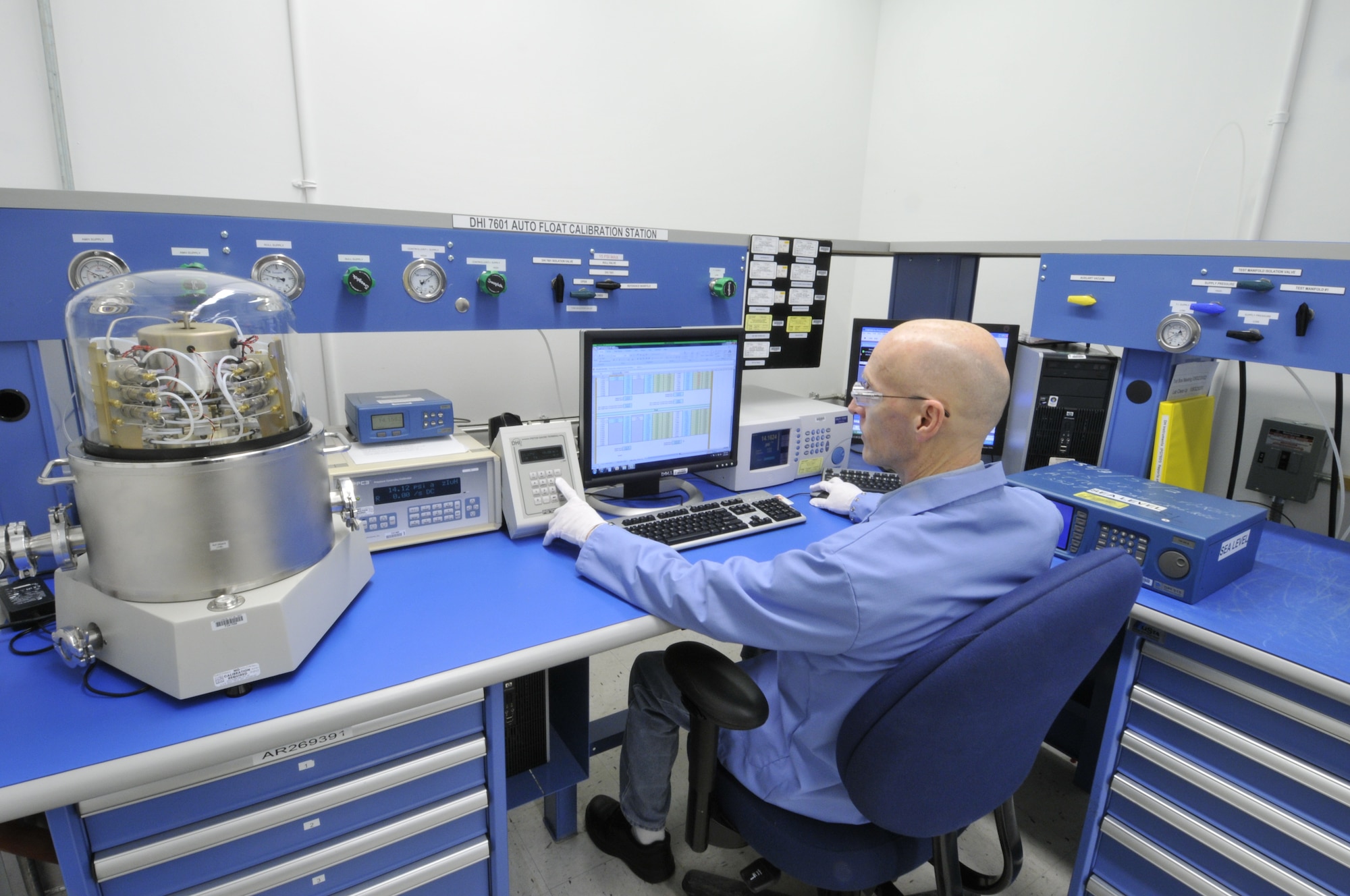 AEDC PMEL Instrument Technician Danny Myers calibrates a pressure controller using a primary pressure standard. (Photo by Rick Goodfriend)