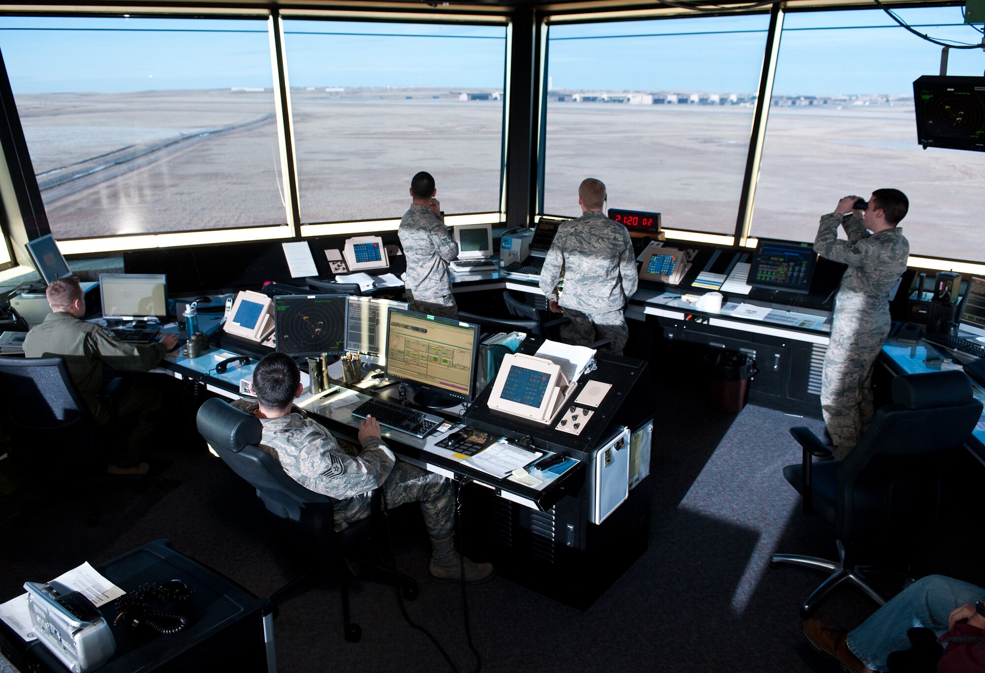 Air traffic controllers from the 28th Operations Support Squadron observe an aircraft as it approaches the runway at Ellsworth Air Force Base, S.D., Nov. 27, 2012. Tower workers relay information to pilots and Airmen in radar approach control to coordinate the arrival and departure of all aircraft transiting Ellsworth. (U. S. Air Force photo by Airman 1st Class Alystria Maurer/Released)