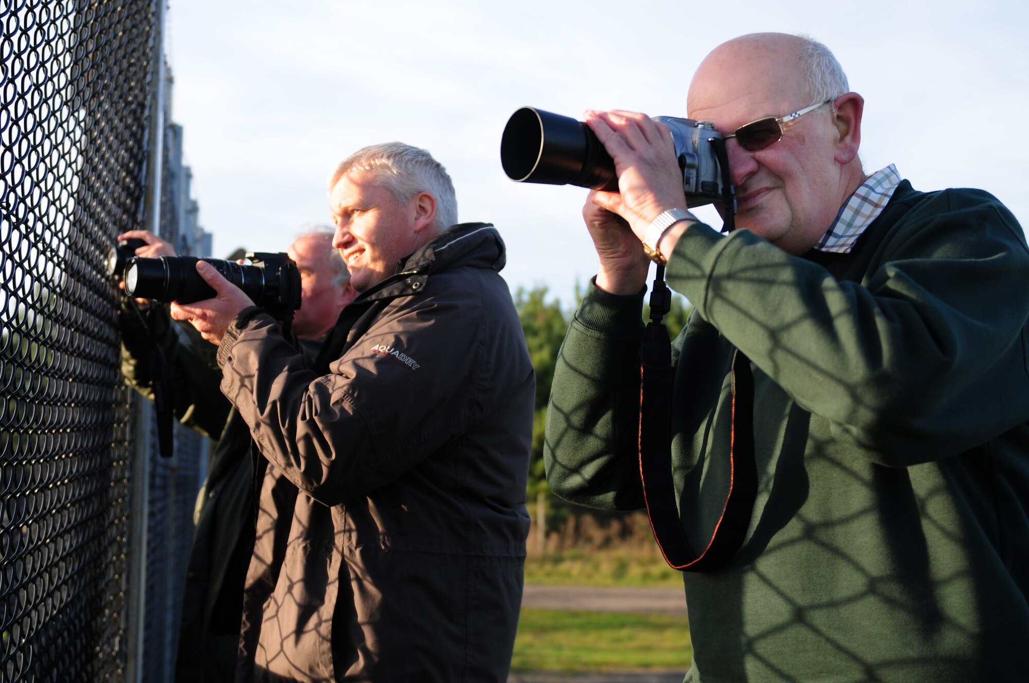 ROYAL AIR FORCE LAKENHEATH, England – (From left) Tony “Ace” Gifford, a native of Lakenheath, England, David White, a native of Hertfordshire, England and Brian Monk, a native of Essex, England, take photos of aircraft at the viewing area Nov. 13, 2012. Spotter Watch provides the spotters an avenue to report suspicious activity outside the gates of the base. (U.S. Air Force photo by Senior Airman Lausanne Morgan)