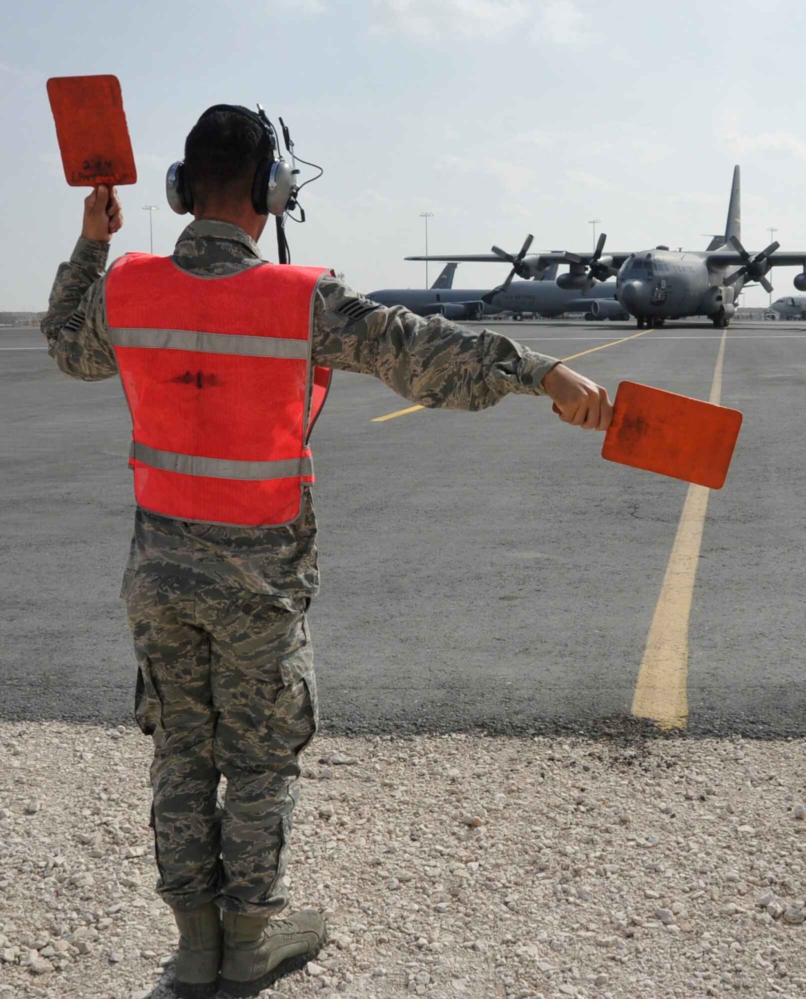 Staff Sgt. Joshua Evans, 746th Expeditionary Aircraft Maintenance Unit crew chief, marshalls a C-130 Hercules into its parking spot shortly after it landed at the 379th Air Expeditionary Wing Nov. 27. The 746 EAMU crew chiefs, deployed from Yakota Air Base, Japan, support deployed C-130s which provide intra-theater combat airlift support throughout Southwest Asia. Since the team’s arrival to the 379th Air Expeditionary Wing in September, they have been responsible for more than 100 sorties carrying nearly 900 passengers and 415 tons of cargo. Evans is a native of Tampa, Fla. (U.S. Air Force photo/Senior Airman Bryan Swink)