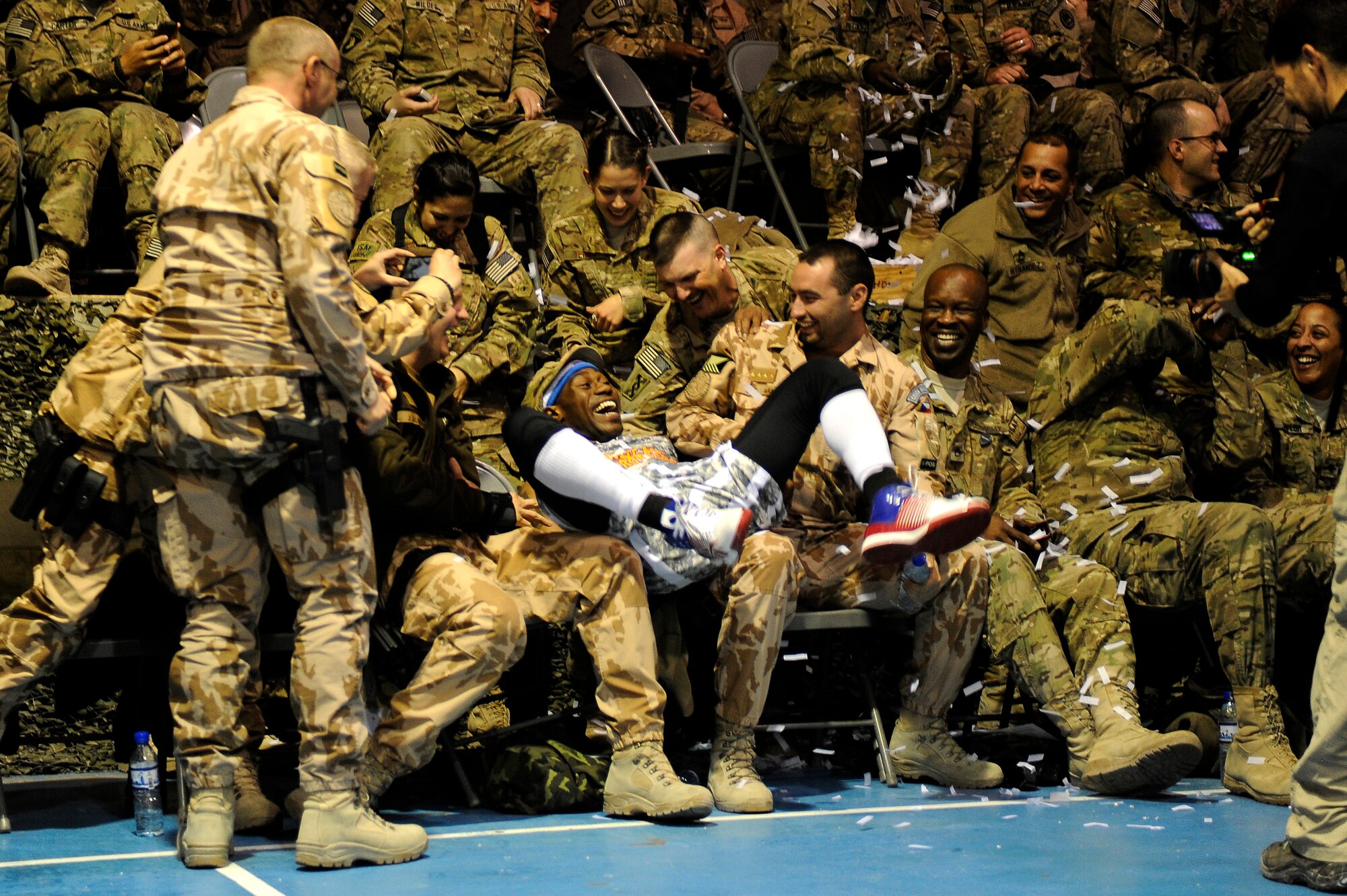 A Globetrotter gag lands “Firefly” Fisher in the laps of surprised servicemembers at Bagram Airfield, Afghanistan, Nov. 28, 2012. The visit was the first for the Globetrotters to Afghanistan, making it the 121st country and territory the team visited. (U.S. Air Force photo/ Master Sgt. Jun Kim)
