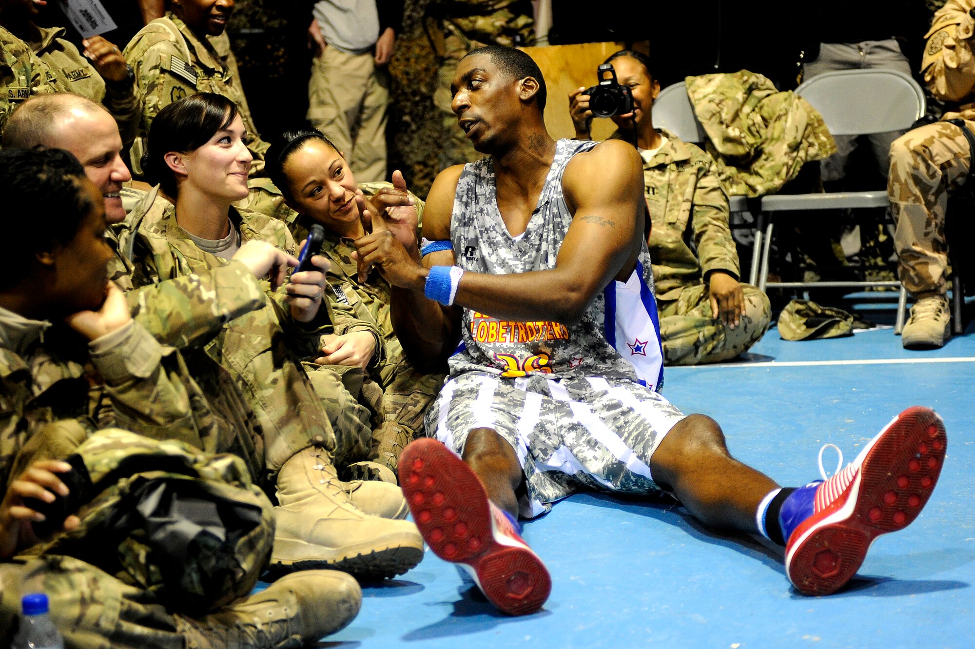 “Hi-Lite” Bruton takes an unscheduled personal timeout to engage U.S. servicemembers in conversation at Bagram Airfield, Afghanistan, Nov. 28, 2012. The visit was the first for the Globetrotters to Afghanistan, making it the 121st country and territory the team visited. (U.S. Air Force photo/ Master Sgt. Jun Kim)