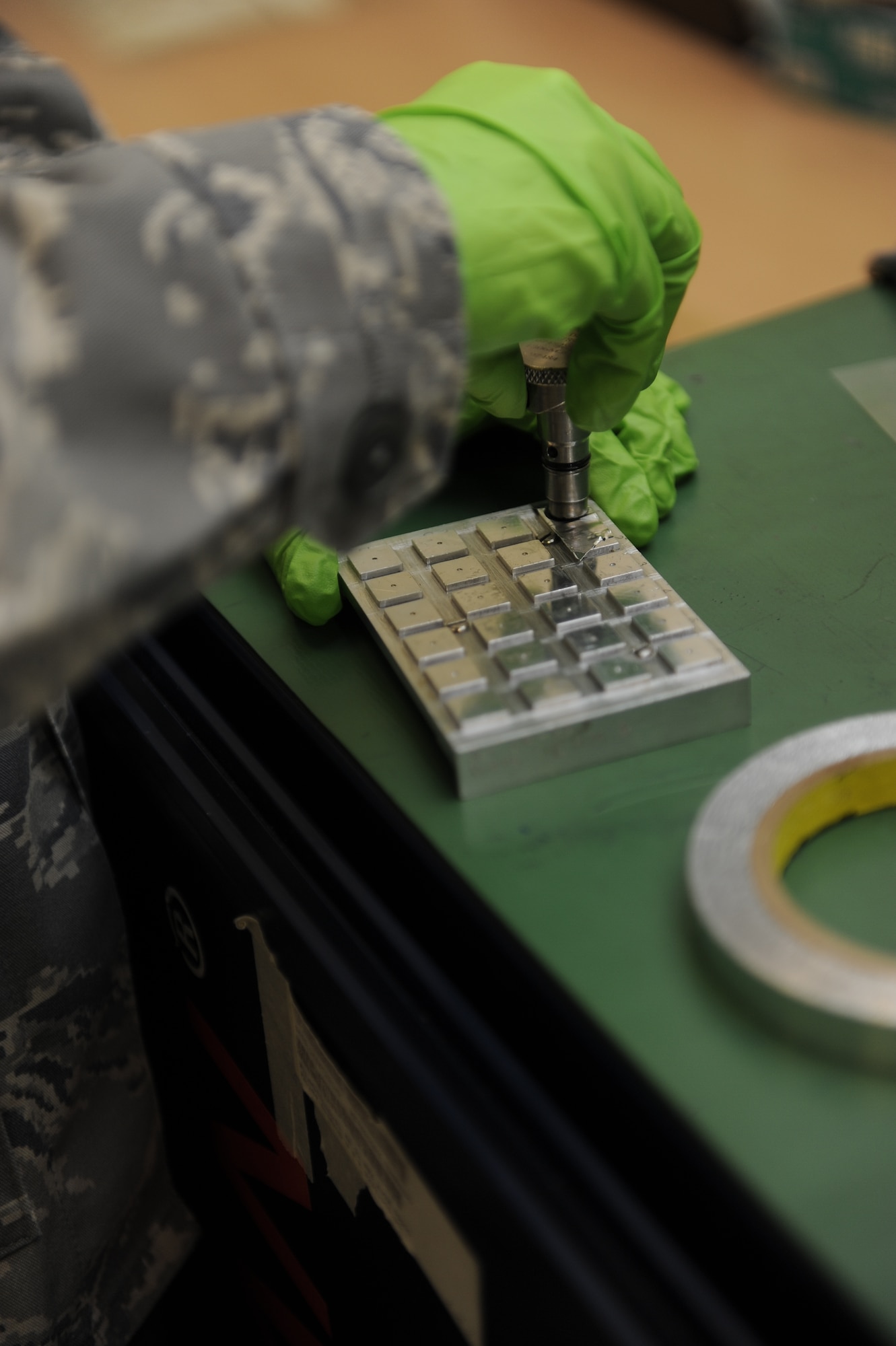 Staff Sgt. Morgan Quinn, 8th Maintenance Squadron nondestructive inspection assistance section chief tests carbon residue from a magnetic chip detector on Kunsan Air Base, Republic of Korea, Nov. 21, 2012. The magnetic chip detector allows NDI to test the aircraft engine for wears with the different metals found on the magnet. (U.S. Air Force photo by Senior Airman Marcus Morris/Released)