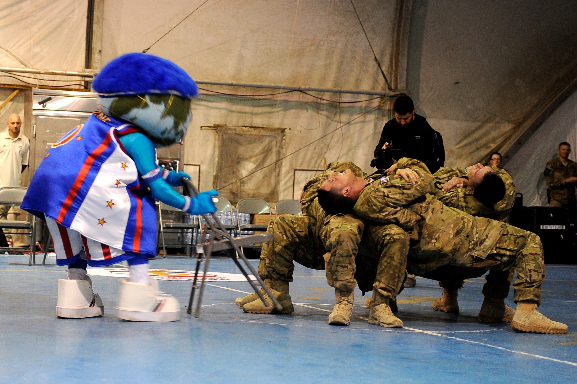 With the help of volunteer U.S. servicemembers, “Globie” warms up the crowd with a magic trick at Bagram Airfield, Afghanistan, Nov. 28, 2012. The visit was the first for the Globetrotters to Afghanistan, making it the 121st country and territory the team visited. (U.S. Air Force photo/ Master Sgt. Jun Kim)