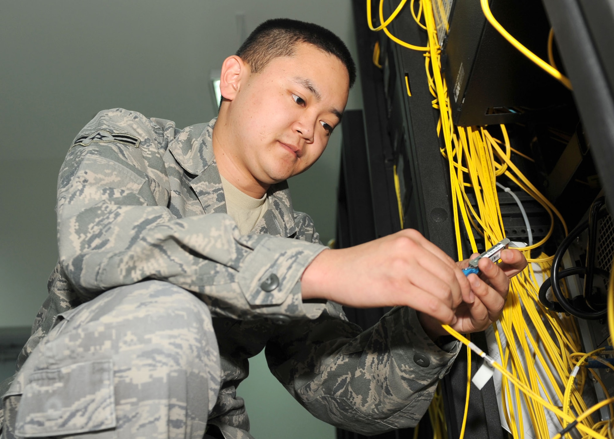 SOUTHWEST ASIA – Airman 1st Class Basil Kim, 379th Expeditionary Communications Squadron Network Management apprentice, fixes a problem on the moral network Nov. 28. At any given time between 3,000 and 6,000 people might be using it. The network comes to the base commercially, but the hardware and infrastructure is completely maintained by the communications squadron. Kim is deployed from the 31st Communications Squadron at Aviano Air Base, Italy. (U.S. Air Force photo/Senior Airman Joel Mease)