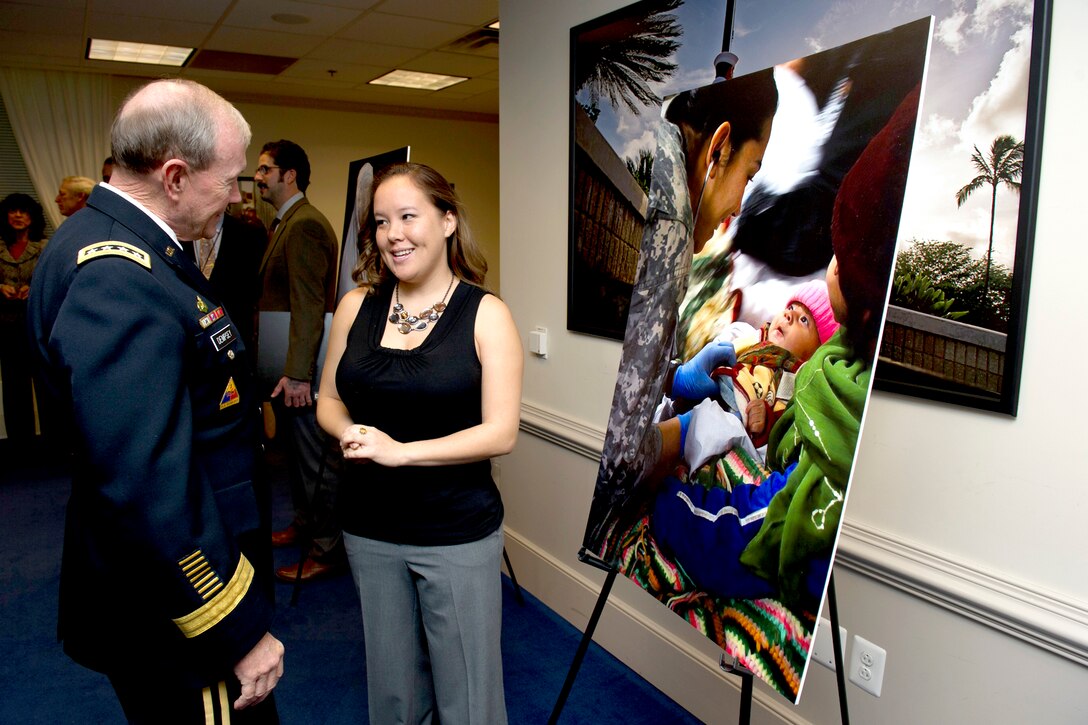 Army Gen. Martin E. Dempsey, chairman of the Joint Chiefs of Staff, speaks with Army Sgt. Monica Smith of Kentucky at the Art in Embassies best in show awards ceremony at the Pentagon, Nov. 30, 2012.