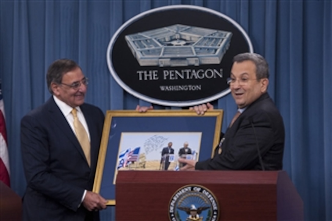 Secretary of Defense Leon E. Panetta, left, presents Israeli Minister of Defense Ehud Barak with a framed photograph from his visit to one of Israel's Iron Dome sites in August of 2012 during a joint press conference in the Pentagon on Nov. 29, 2012.  Panetta and Barack met earlier to meet to discuss national and regional security items of interest to both nations.  Panetta awarded Barack the Department of Defense Medal for Distinguished Public Service before taking questions from the press.  