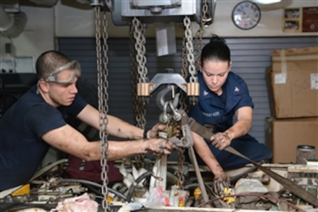 U.S. Navy Petty Officer 2nd Class Cesar Gonzalez, left, and Petty Officer 3rd Class Vanessa Lindsay-Kerr prepare to remove an engine from an aircraft tractor for repair onboard the aircraft carrier USS John C. Stennis (CVN 74) as the ship operates in the Arabian Sea on Nov. 29, 2012. Gonzalez and Lindsay-Kerr are Navy aviation support equipment technicians.  The Stennis is deployed to the 5th Fleet area of responsibility to conduct maritime security operations and theater security cooperation efforts.  