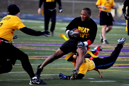 Major Corey Edmonds (J3) dodges left passed ISI S1 Brett Garrett (left, JFCC-GS) and LT Jon Stockton (bottom, JFCC-GS) during the annual USSTRATCOM Army/Navy football game played 30 November at Bellevue West High School. Army defeated Navy with a final score of 18 - 6.