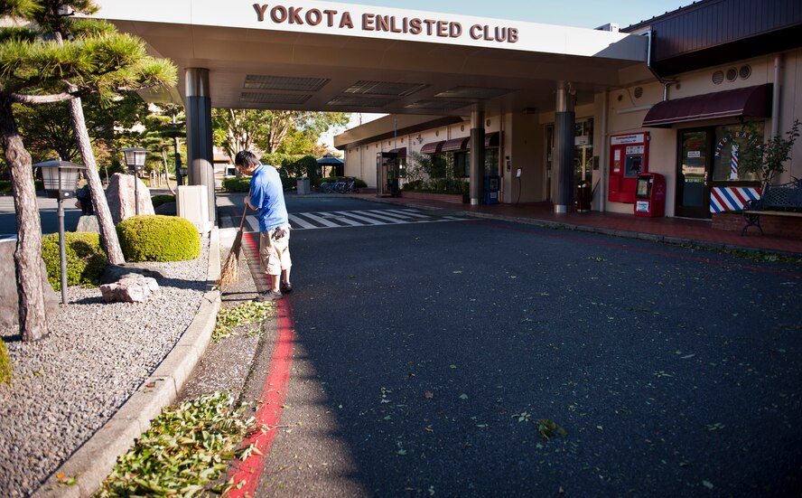 YOKOTA AIR BASE, Japan -- Masahiro Morita, Yokota Enlisted Club employee, sweeps debris left from Typhoon Jelawat at Yokota Air Base, Japan, Oct. 1, 2012. The official typhoon season for the Northwest Pacific is June 1 to Nov. 30; however, the peak for Yokota is between August and September.  (U.S. Air Force photo by Airman 1st Class Krystal M. Garrett) 