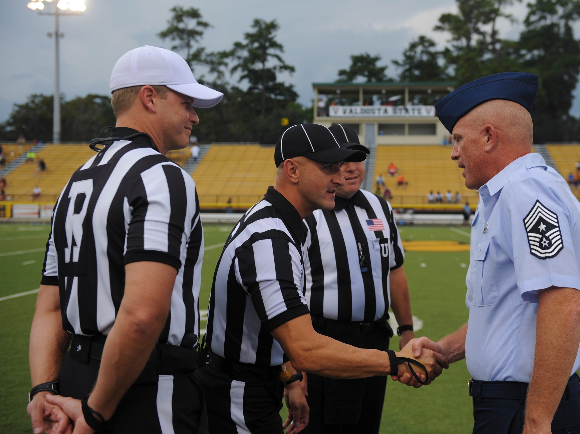 U.S. Air Force Chief Master Sgt. Frank Batten, 23d Wing command chief, greets the referees during the Valdosta State University Military Appreciation Night at the Bazemore-Hyder Stadium in Valdosta, Ga., Sept. 29, 2012. The game was between the VSU Blazers and the Edward Waters College Tigers. (U.S. Air Force photo by Airman 1st Class Olivia Dominique/Released)