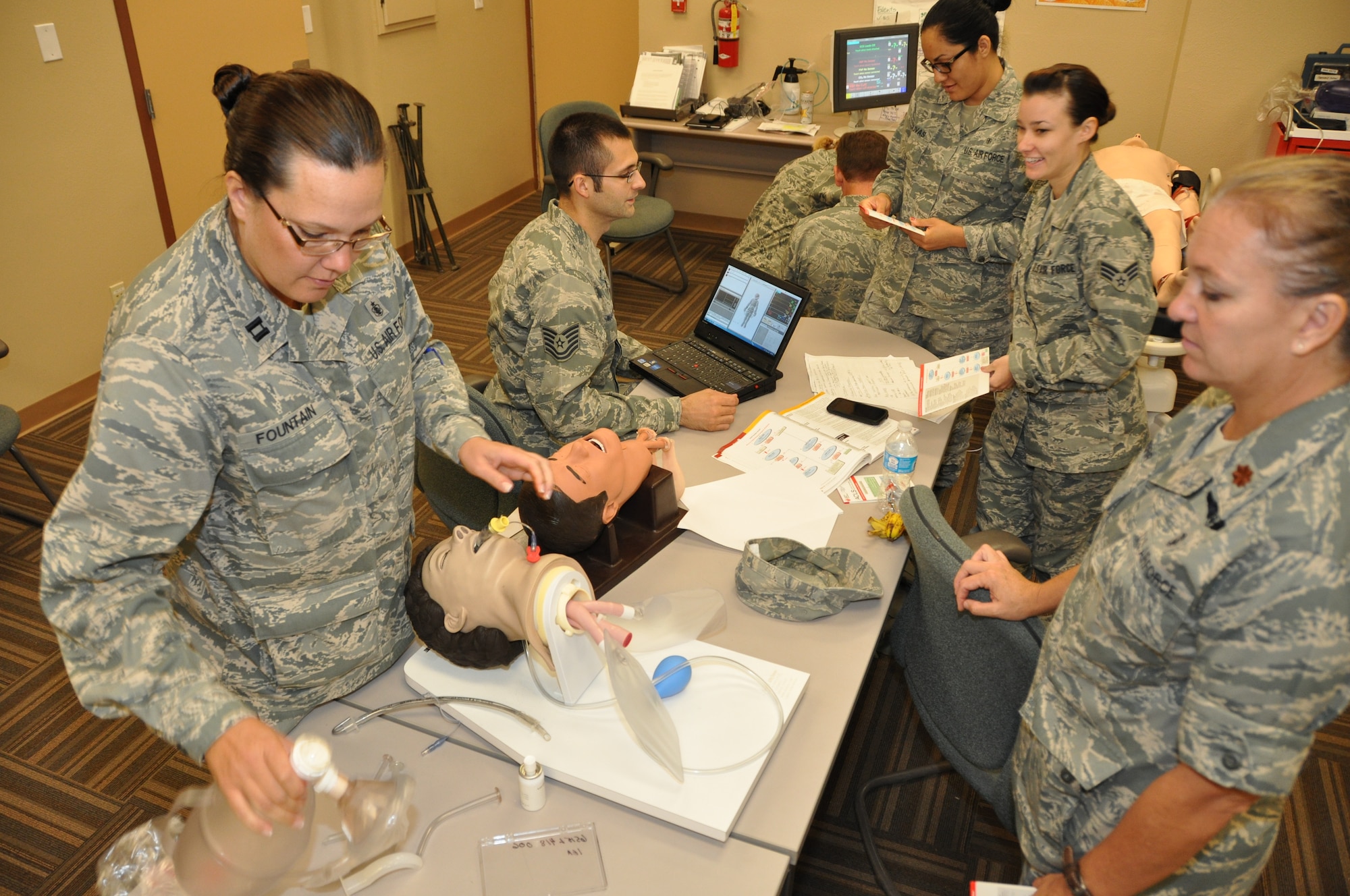 Members from the 944th Aeromedical Staging Squadron and 944th Medical Squadron participate in an Advanced Cardio Pulmonary Life Support training class at the 944th ASTS simulation lab, Luke Air Force Base, Ariz., Sept. 9, 2012. Capt. Angela L. Fountain, far left, and Maj. Denise E. Derr, far right, nurses with the 944th MDS use bag valve masks to open and maintain airways on mannequin heads. In the background, from left, Tech. Sgt. Christopher T. Martin, the cardiopulmonary technician on the Critical Care Air Transport Team with the 944th ASTS reviews training scenarios for the Laerdal SimMan 3G with Senior Airman Gabriela F. Olivas and Senior Airman Lysa M. Busalachi, medical technicians with the 944th ASTS. (U.S. Air Force photo/Tech. Sgt. Phyllis E. Keith) 
