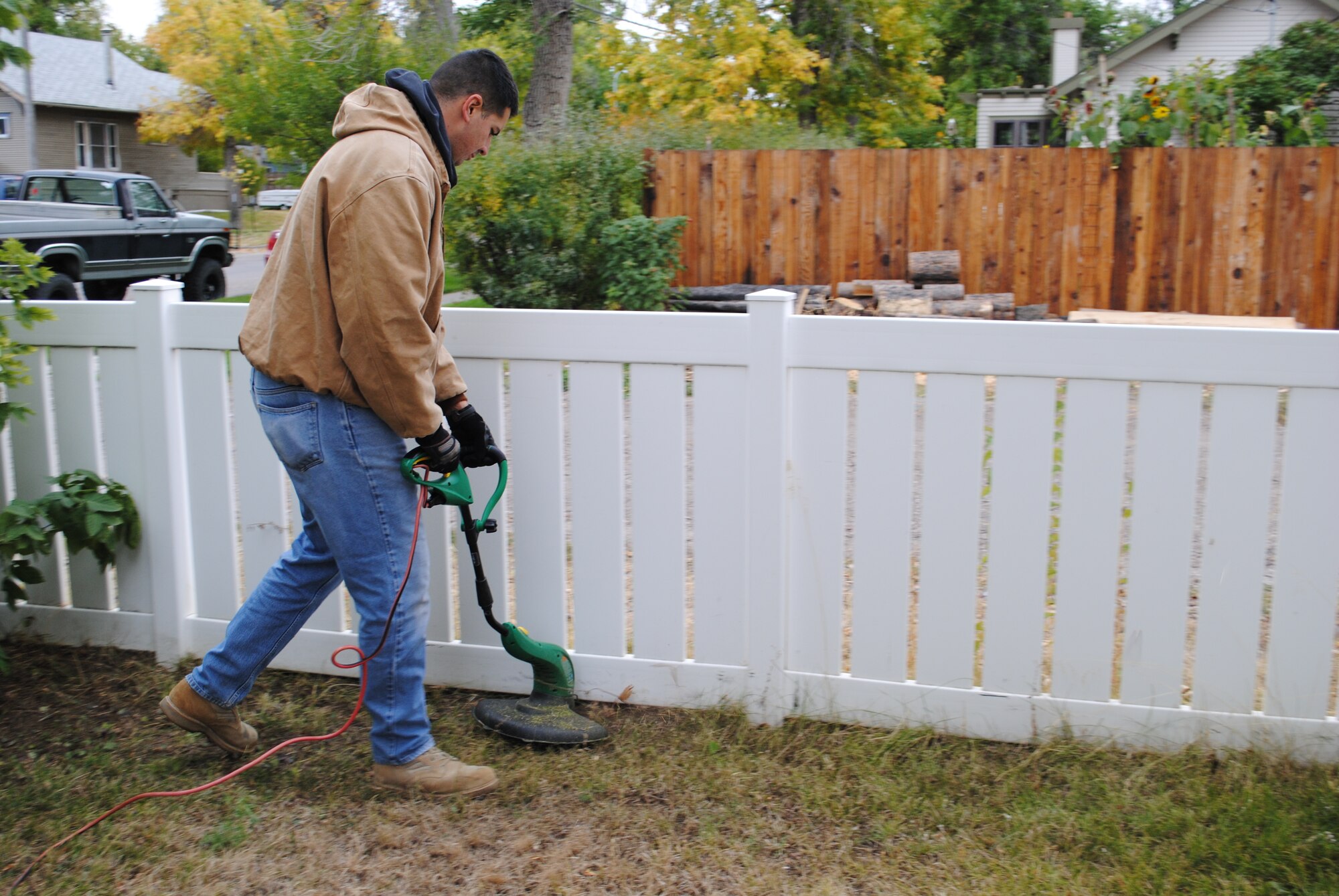 A member of Team Malmstrom trims the grass along a Great Falls resident’s fence during last year’s Day of Caring. To volunteer to help with this year’s event, contact Master Sgt. Edgar Ulrich at 731-2671 or sign up on the 10-day share drive under CFC Day of Caring 2012. (U.S. Air Force photo/Airman Cortney Paxton)