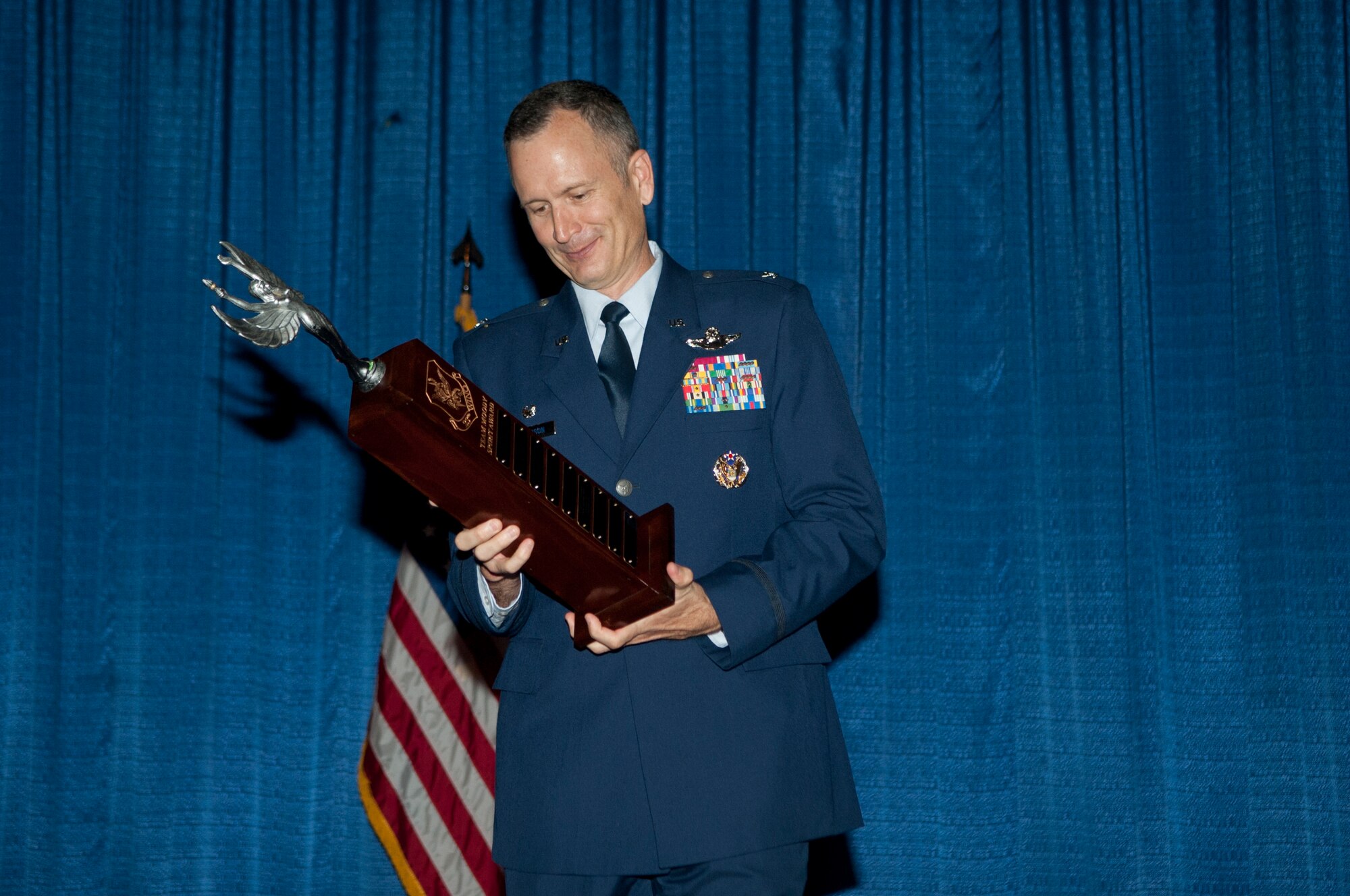 U.S. Air Force Col. Billy Thompson, 23d Wing commander, holds the spirit award during a NCO promotion ceremony at Moody Air Force Base, Ga., Sept. 28, 2012. The 23d Component Maintenance Squadron won the award for showing the most spirit in supporting the new promotees throughout the ceremony. (U.S. Air Force photo by Airman 1st Class Paul Francis/Released)

