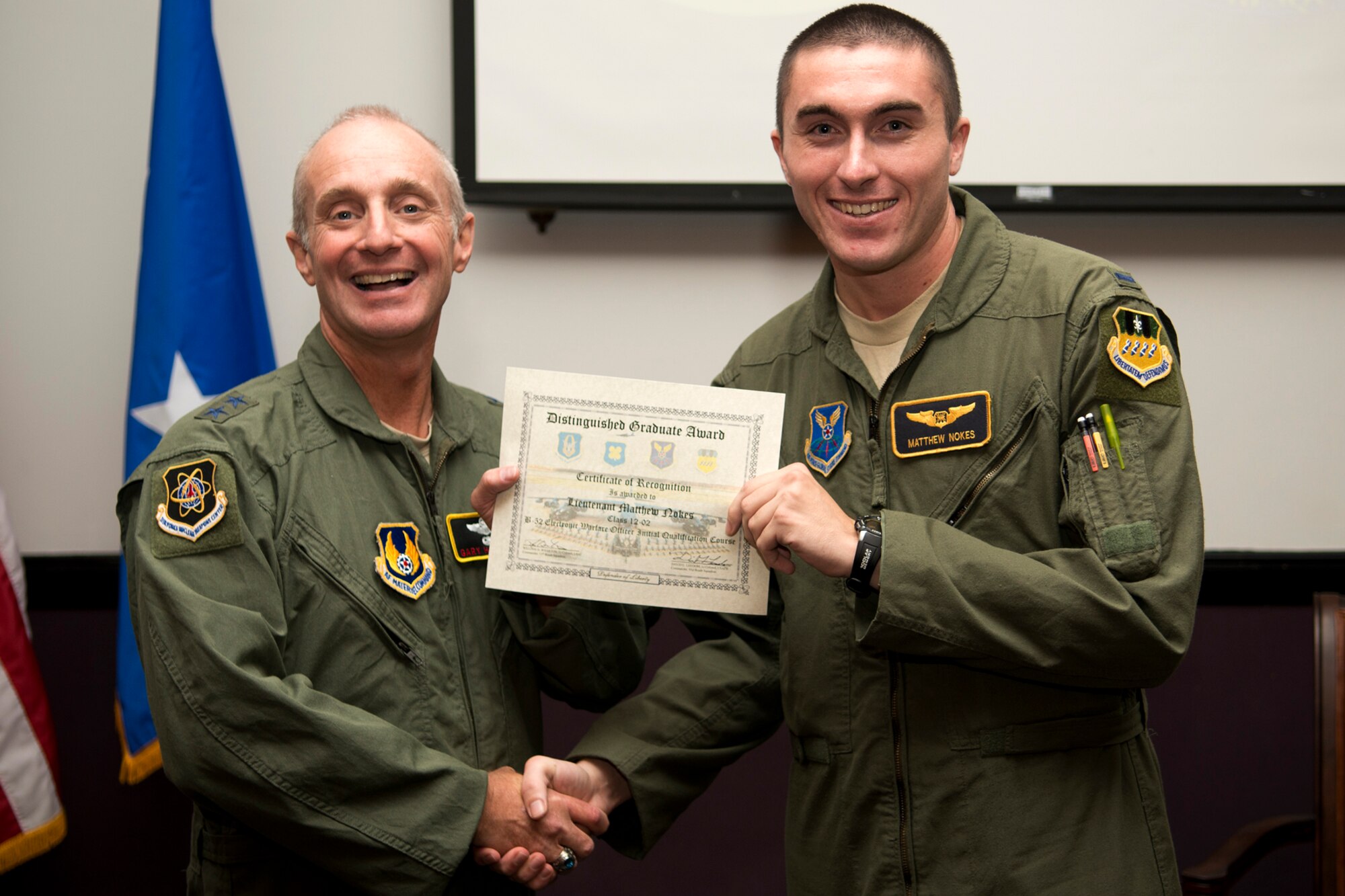 U.S. Air Force Maj. Gen. Garrett Harencak, Air Force Nuclear Weapons Center commander, presents the Electronic Warfare Officer Distinguished Graduate award to 1st Lt. 1st Lt. Matthew Nokes during a B-52 Formal Training Unit Graduation ceremony, Sept. 28, 2012, Barksdale Air Force Base, La. The Distinguished Graduate Award is a culmination of academic tests, flight evaluations, officership, attitude and professional bearing, and the winner is selected by having demonstrated training and performance that was consistently and clearly above their peers. (U.S. Air Force photo by Master Sgt. Greg Steele/Released)