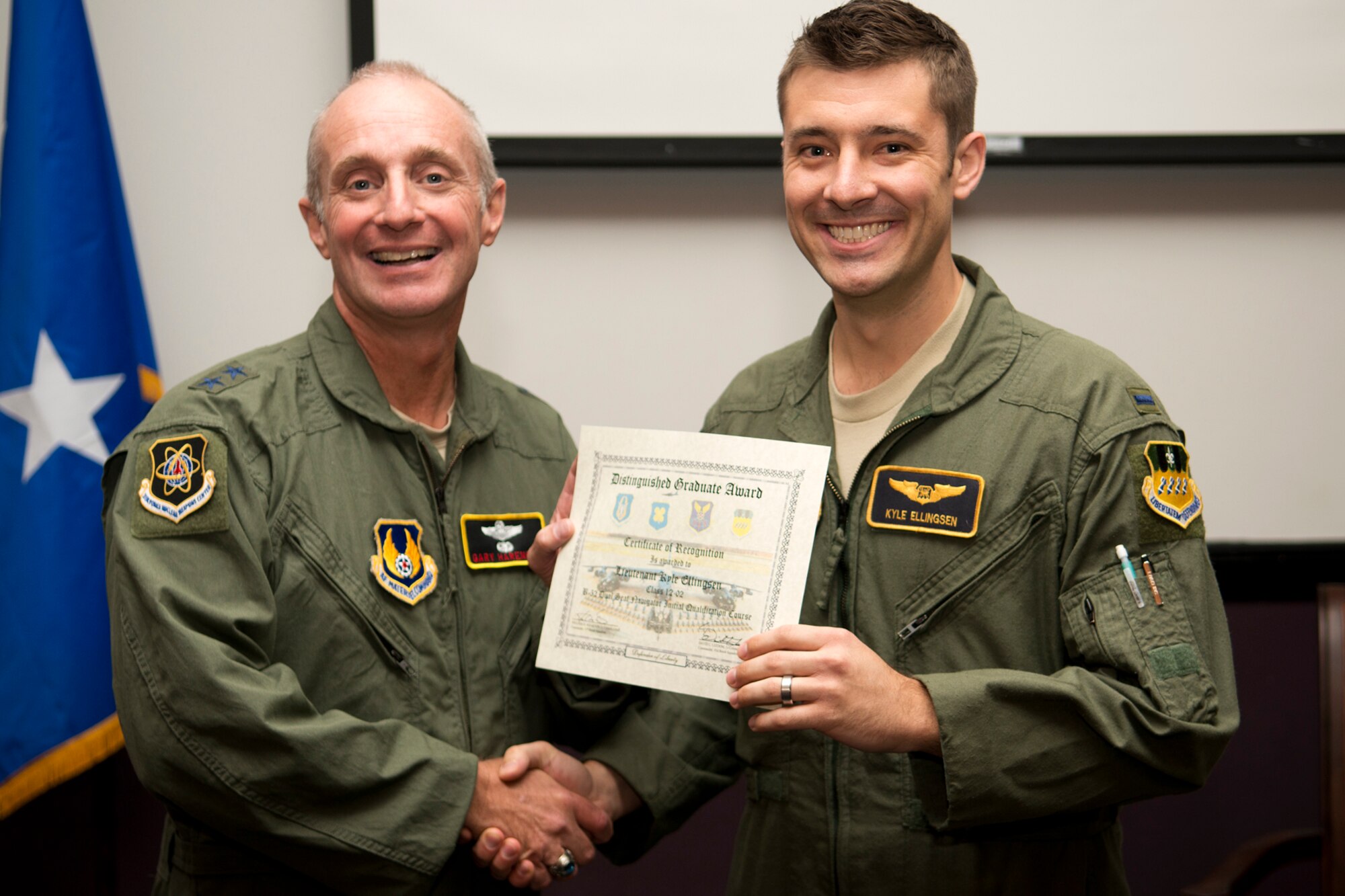 U.S. Air Force Maj. Gen. Garrett Harencak, Air Force Nuclear Weapons Center commander, presents the Dual Seat Navigator Distinguished Graduate award to 1st Lt. 1st Lt. Kyle Ellingsen during a B-52 Formal Training Unit Graduation ceremony, Sept. 28, 2012, Barksdale Air Force Base, La. The Distinguished Graduate Award is a culmination of academic tests, flight evaluations, officership, attitude and professional bearing, and the winner is selected by having demonstrated training and performance that was consistently and clearly above their peers. (U.S. Air Force photo by Master Sgt. Greg Steele/Released)