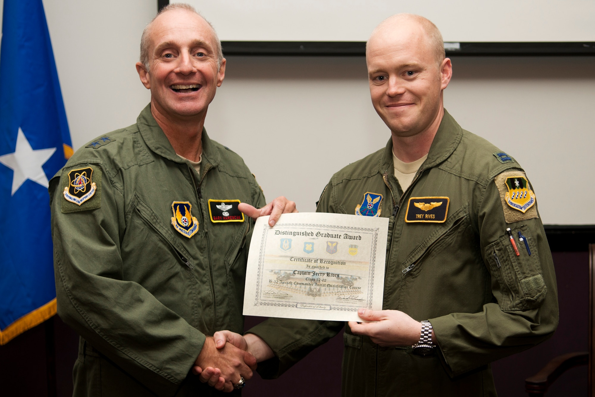 U.S. Air Force Maj. Gen. Garrett Harencak, Air Force Nuclear Weapons Center commander, presents the Aircraft Commander Distinguished Graduate award to Capt. Jerry Rives during a B-52 Formal Training Unit Graduation ceremony, Sept. 28, 2012, Barksdale Air Force Base, La. The Distinguished Graduate Award is a culmination of academic tests, flight evaluations, officership, attitude and professional bearing, and the winner is selected by having demonstrated training and performance that was consistently and clearly above their peers. (U.S. Air Force photo by Master Sgt. Greg Steele/Released)