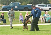 Staff Sgt. Matthew Phillips and Senior Airman George Garcia, 902nd Security Forces Squadron military working dog handlers, demonstrate K-9 capabilities to members of The Forum at Lincoln Heights, a local retirement community, during their visit to Joint Base San Antonio-Randolph Sept. 27. (U.S. Air Force photo by Benjamin Faske)