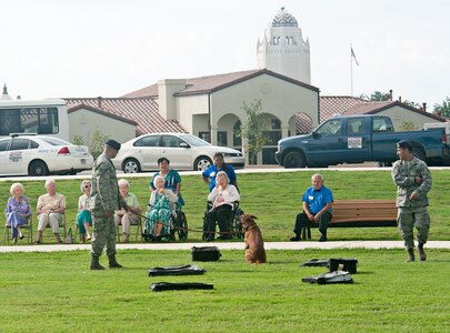 Tech. Sgt. Santiago Bernal and Staff Sgt. Jonathan Royce, 902nd Security Forces Squadron military working dog handlers, demonstrate K-9 detection capabilities to members of The Forum at Lincoln Heights, a local retirement community, during their visit to Joint Base San Antonio-Randolph Sept. 27. (U.S. Air Force photo by Benjamin Faske)