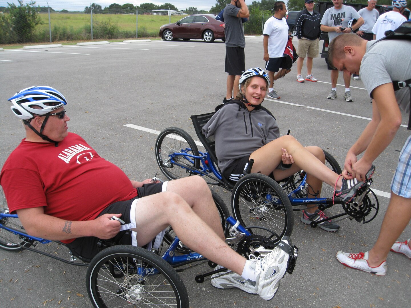 Former Staff Sgt. Claude Owens and retired Senior Airman Ramina Oraha prepare for a recumbent bike ride along the flightline at Joint Base San Antonio-Randolph, Texas. Assisting Oraha is her brother, Mike. Cycling was one of the sports offered during an Air Force Adaptive Sports Program camp Sept. 14 and 15. (U.S. Air Force photo/Tammy Cournoyer)