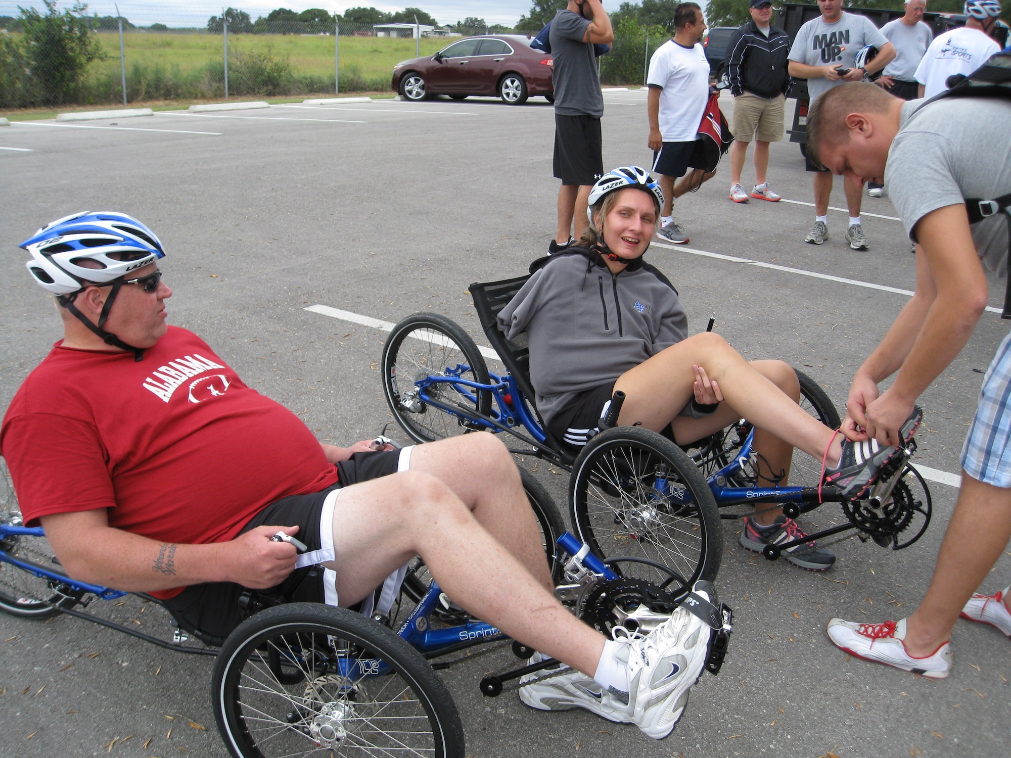 Former Staff Sgt. Claude Owens and retired Senior Airman Ramina Oraha prepare for a recumbent bike ride along the flightline at Joint Base San Antonio-Randolph, Texas. Assisting Oraha is her brother, Mike. Cycling was one of the sports offered during an Air Force Adaptive Sports Program camp Sept. 14 and 15. (U.S. Air Force photo/Tammy Cournoyer)