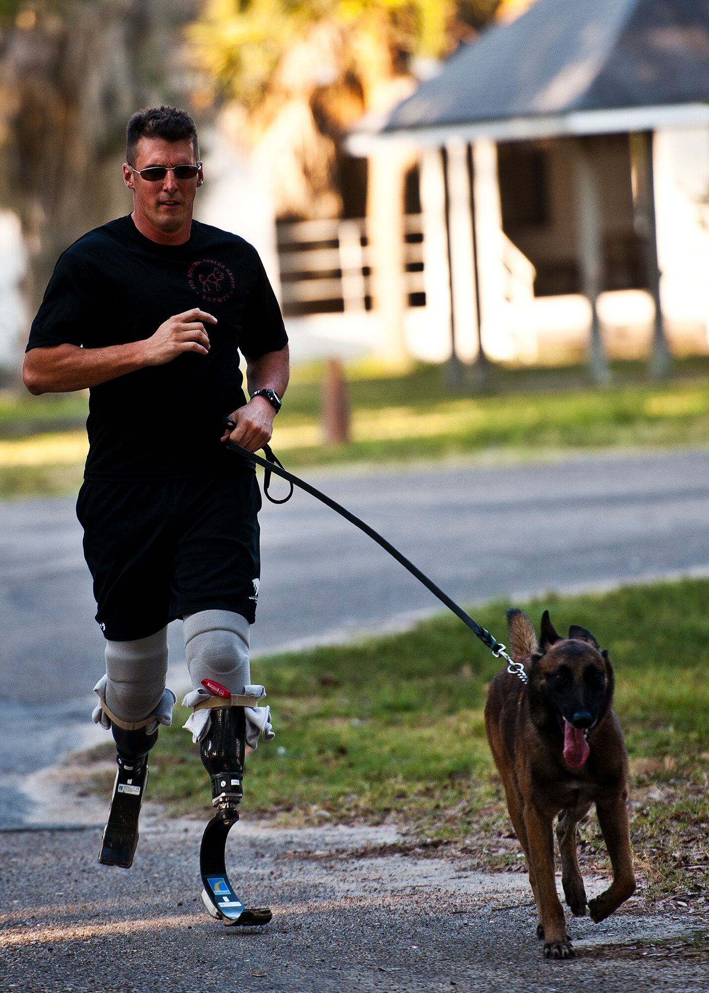 A Soldier from 7th Special Forces Group K-9 unit and their dogs cross the finish line at the first-ever Wounded Warrior 5K run at Eglin Air Force Base, Fla., Sept. 28.  The run was to support Leonard Anderson, a former 96th Security Forces Squadron K-9 handler, after he was wounded during a deployment to Afghanistan.  More than 200 Team Eglin members turned out to run and show their support.  (U.S. Air Force photo/Samuel King Jr.)
