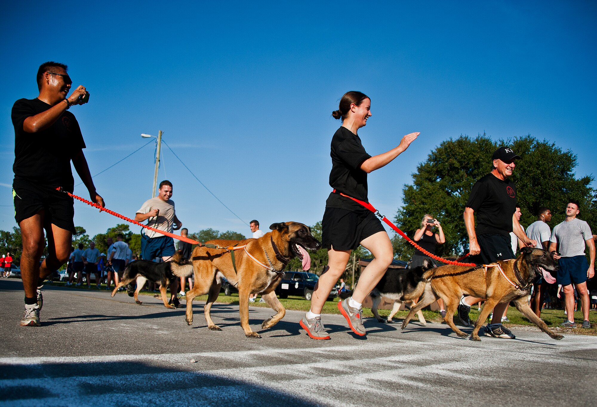 Soldiers from 7th Special Forces Group K-9 unit and their dogs cross the finish line at the first-ever Wounded Warrior 5K run at Eglin Air Force Base, Fla., Sept. 28.  The run was to support Leonard Anderson, a former 96th Security Forces Squadron K-9 handler, after he was wounded during a deployment to Afghanistan.  More than 200 Team Eglin members turned out to run and show their support.  (U.S. Air Force photo/Samuel King Jr.)
