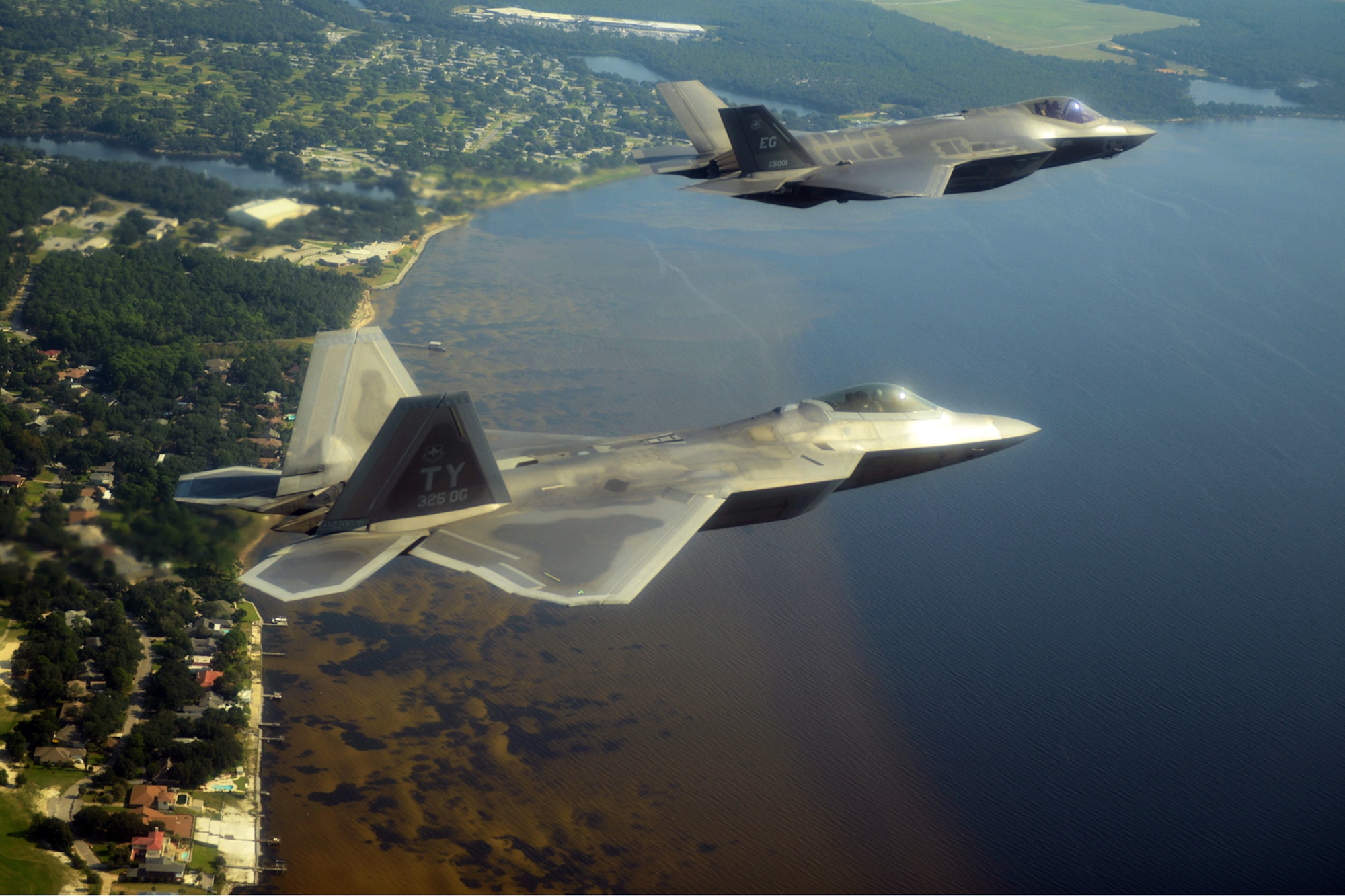 An F-35A Lightning II joint strike fighter from the 33rd Fighter Wing at Eglin Air Force Base, Fla., and an F-22A Raptor from the 325th Fighter Wing at Tyndall Air Force Base, Fla., soar over the Emerald Coast Sept. 19, 2012. The flight marked the first time the two fifth-generation fighters have flown together for the Air Force. (Air Force Photo)