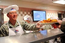 Chief Master Sgt. Karl Ohrn, 319th Medical Group superintendent, hands Airmen their meals during the Airmen Appreciation Dinner, Sept. 26, 2012, at the Airey Dining Facility on Grand Forks Air Force Base, N.D. Dinners such as this are held during different times of the year by the 319th Air Base Wing senior leadership to thank Airmen for all they do to get the mission done. (U.S. Air Force photo /Staff Sgt. Amanda N. Grabiec)