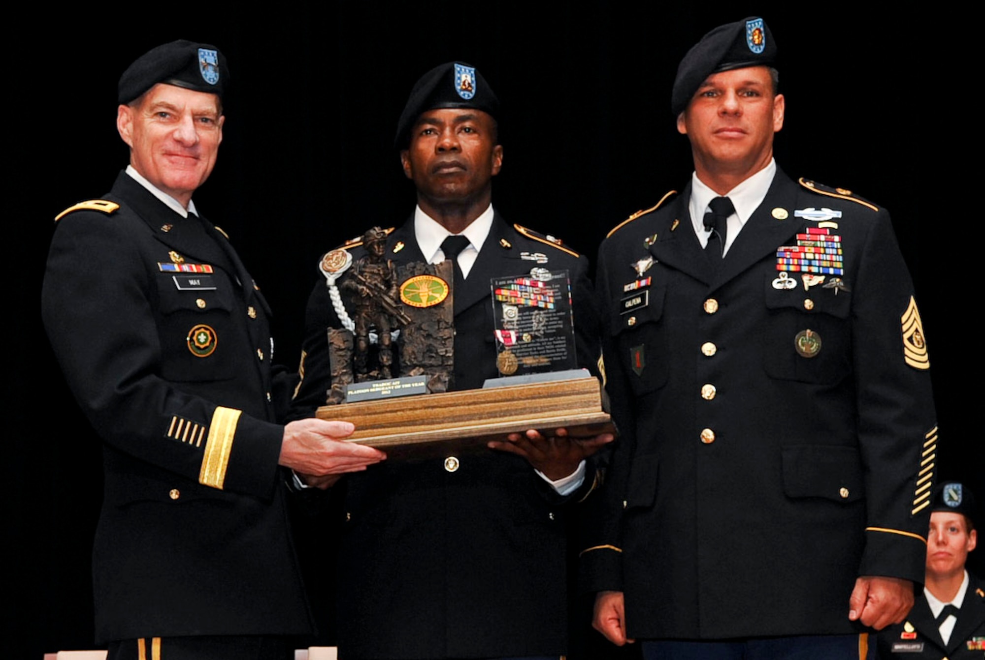 U.S. Army Sgt. 1st Class Delroy Barnett (center), an Advanced Individual Training platoon sergeant from the 32nd Medical Brigade at Fort Sam Houston, Texas, receives the 2012 AIT Platoon Sergeant of the Year award from Maj. Gen. Bradley May (left), Initial Military Training Center of Excellence deputy commanding general, and Sgt. Maj. John R. Calpena, IMT CoE command sergeant major, during a ceremony at Fort Eustis, Va., Sept. 28, 2012. Barnett was selected from among nine platoon sergeants that competed for the title in a week-long competition, designed to test their physical and mental readiness. (U.S. Air Force photo by Staff Sgt. Wesley Farnsworth/Released)