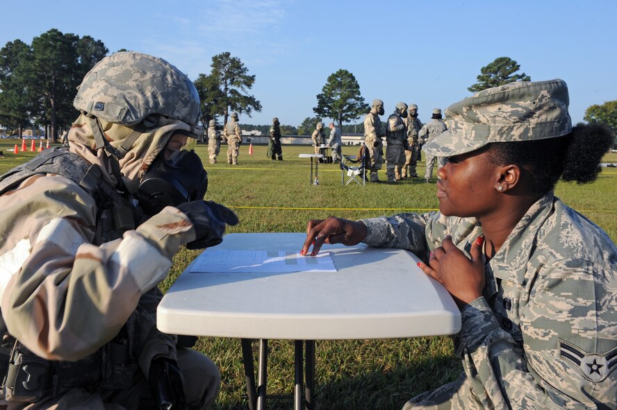 U.S. Air Force Airman 1st Class Bridget Danowski (left), 4th Security Forces Squadron force protector, and Airman 1st Class Brittney Meadows, 4th Civil Engineer Squadron emergency manager, discuss differences in chemical levels during an ability to survive and operate exercise on Seymour Johnson Air Force Base, N.C., Sept. 26, 2012. Airmen detect different chemical levels by examining color and size marks on M-8 paper. (U.S. Air Force photo/Airman 1st Class John Nieves Camacho/Released)