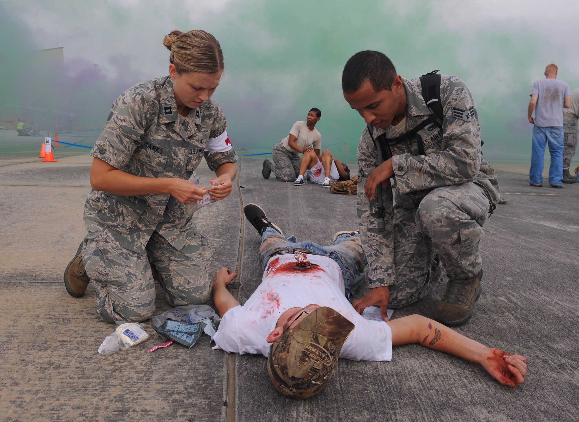 U.S. Air Force Capt. Kathryn Marks, 23d Aerospace Medicine Squadron general dentist, and Senior Airman Marcos Collazo, 23d Equipment Maintenance Squadron aircraft structural maintenance journeyman, treat a moulage victim during a major accident response exercise at Moody Air Force Base, Ga., Sept. 27, 2012. During the exercise, Moody Airmen acted as victims of a simulated plane crash. (U.S. Air Force photo by Airman 1st Class Olivia Dominique/Released)
