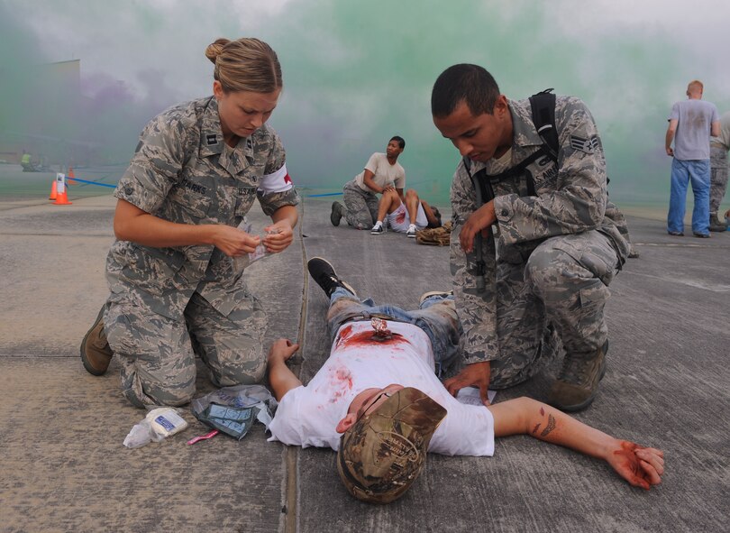 U.S. Air Force Capt. Kathryn Marks, 23d Aerospace Medicine Squadron general dentist, and Senior Airman Marcos Collazo, 23d Equipment Maintenance Squadron aircraft structural maintenance journeyman, treat a moulage victim during a major accident response exercise at Moody Air Force Base, Ga., Sept. 27, 2012. During the exercise, Moody Airmen acted as victims of a simulated plane crash. (U.S. Air Force photo by Airman 1st Class Olivia Dominique/Released)