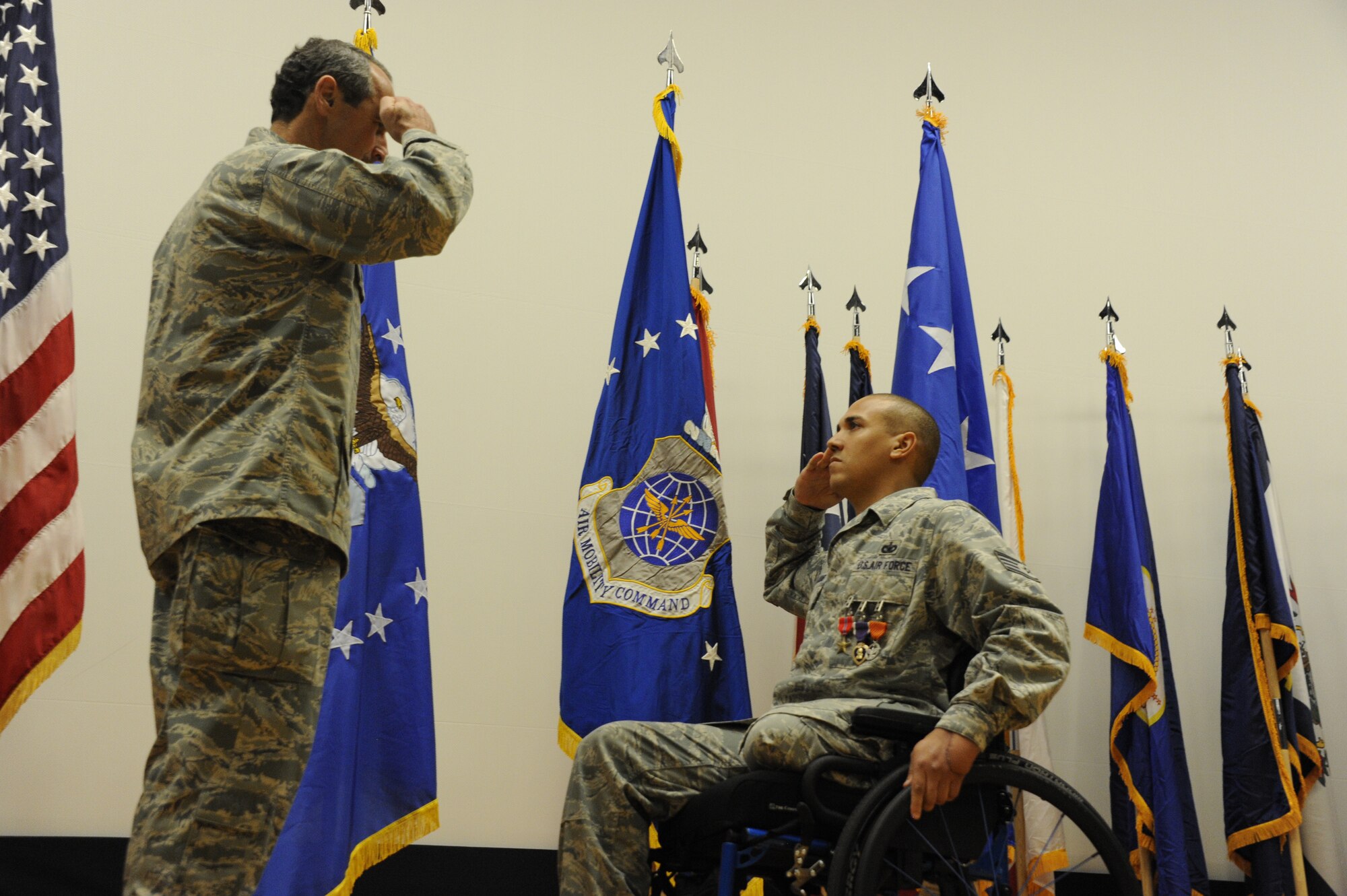 Staff Sgt. Brian Williams, a 87th Security Forces Squadron military working dog handler (right), salutes Gen. Raymond E. Johns, Air Mobility Command commander,  after receiving the Purple Heart, Air Force Combat Action Medal and Bronze Star Medal during his awards ceremony at the Joint Base Theatre here Sept. 28. Williams fell victim to an improvised explosive device attack in southern Afghanistan April 25.
(Official U.S. Air Force photo Russ Meseroll/released)

