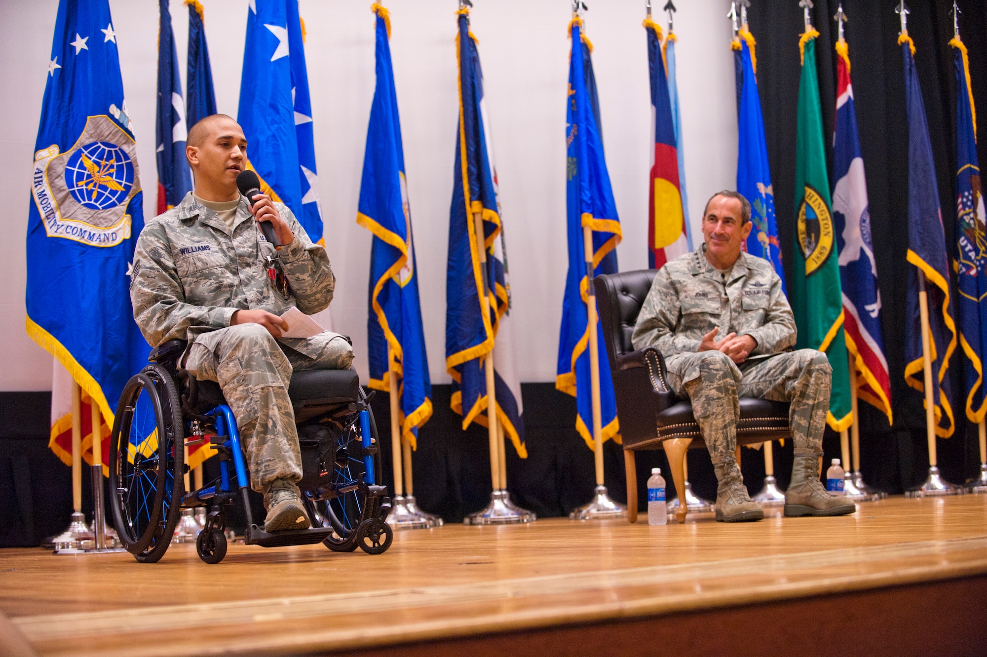 Staff Sgt. Brian Williams, a 87th Security Forces Squadron military working dog handler (left), addresses an audience during his awards ceremony at the Joint Base Theatre here Sept. 28. Williams received the Purple Heart, Air Force Combat Action Medal and Bronze Star Medal from Gen. Raymond E. Johns, Air Mobility Command commander, during the event.

(Official U.S. Air Force photo Russ Meseroll/released)
