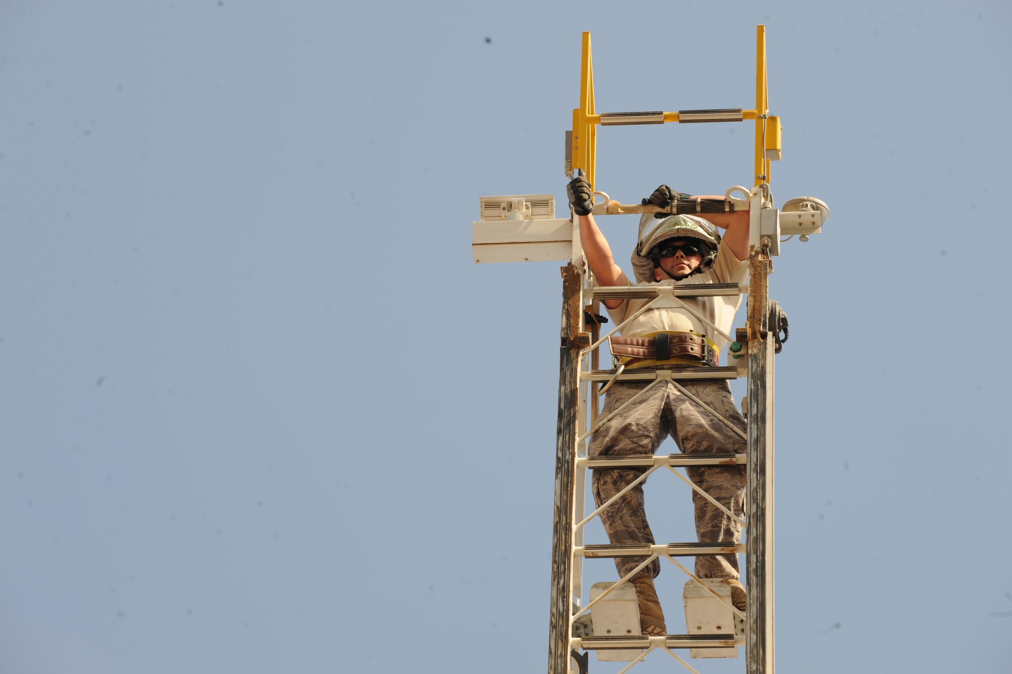SOUTHWEST ASIA – Staff Sgt. Christopher Wood, 386th Expeditionary Civil Engineer Squadron firefighter crew chief, climbs a 77-foot ladder during a practical exam for upgrade training on the driver/operator an aerial device truck here Sept. 28. Firefighters operate the ladder to perform aerial rescue from different levels of the building. The training requires members to elevate themselves on the ladder to run water from their aerial position. (U.S. Air Force photo/Staff Sgt. Alexandra M. Boutte)