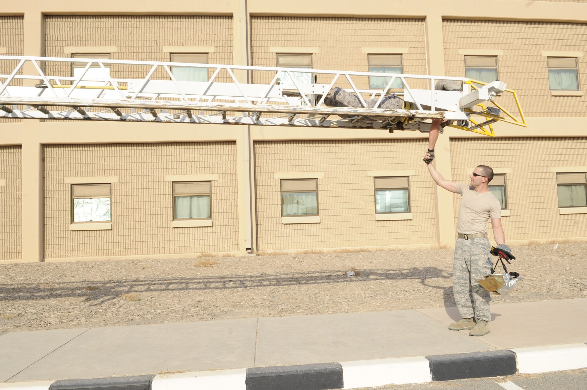SOUTHWEST ASIA – Staff Sgt. Christopher Wood, 386th Expeditionary Civil Engineer Squadron firefighter crew chief, shakes hands with Senior Airman Jaime Aviles, 386th ECES firefighter crew chief, during aerial device training. An aerial device is a ladder truck with water capabilities with elevation. (U.S. Air Force photo/Staff Sgt. Alexandra M. Boutte)
