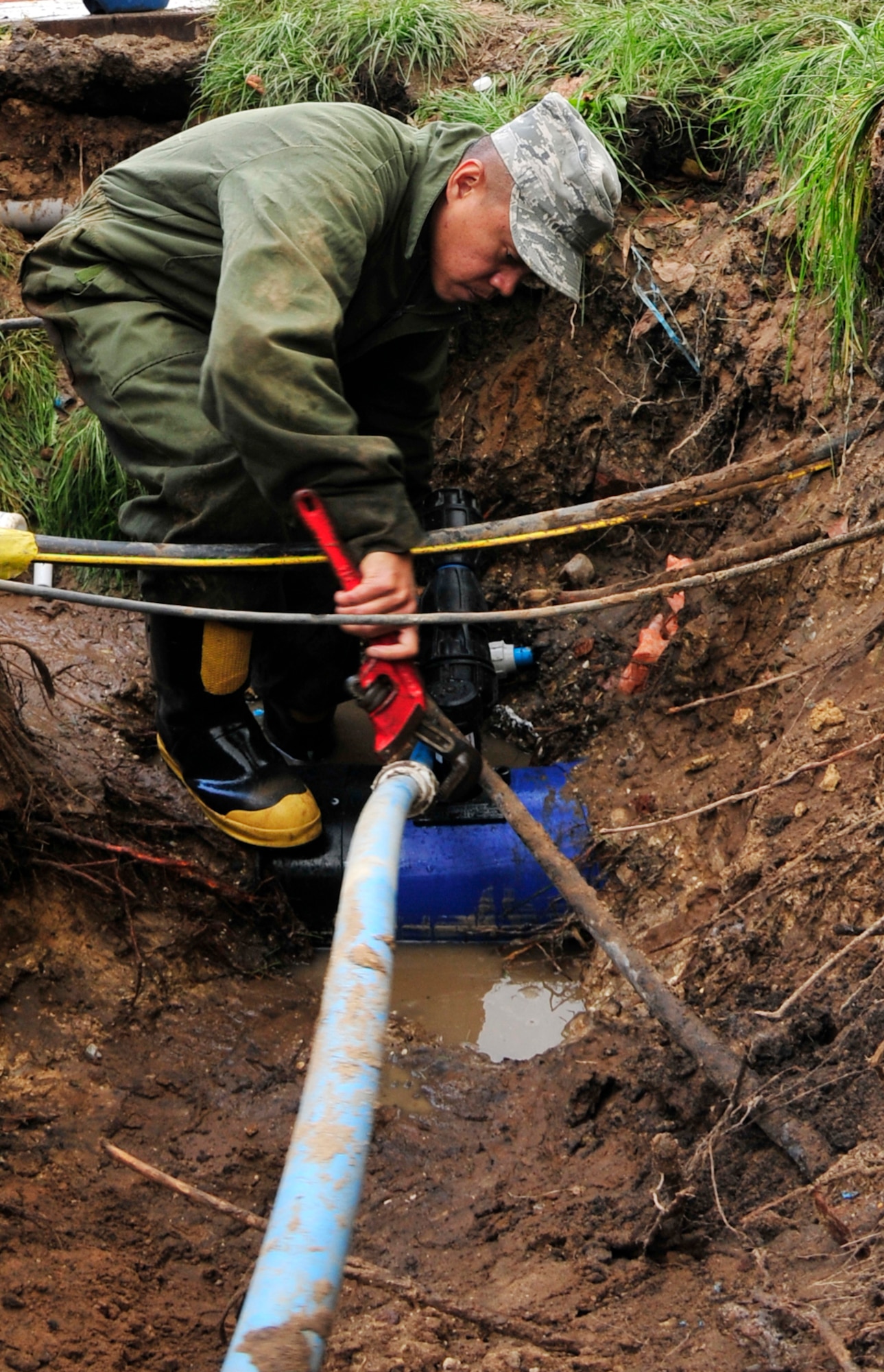 ROYAL AIR FORCE LAKENHEATH, England - Staff Sgt. Mervin Brice, 48th Civil Engineer Squadron water and fuels systems maintenance craftsman, tightens a coupling on a waterline outside of building 1063 Sept. 27, 2012. Airmen from the 48th CES uncovered the site in order to repair a leak. This is just one way in which the 48th CES helps shape the installation. (U.S. Air Force photo by Senior Airman Tiffany M. Grigg)