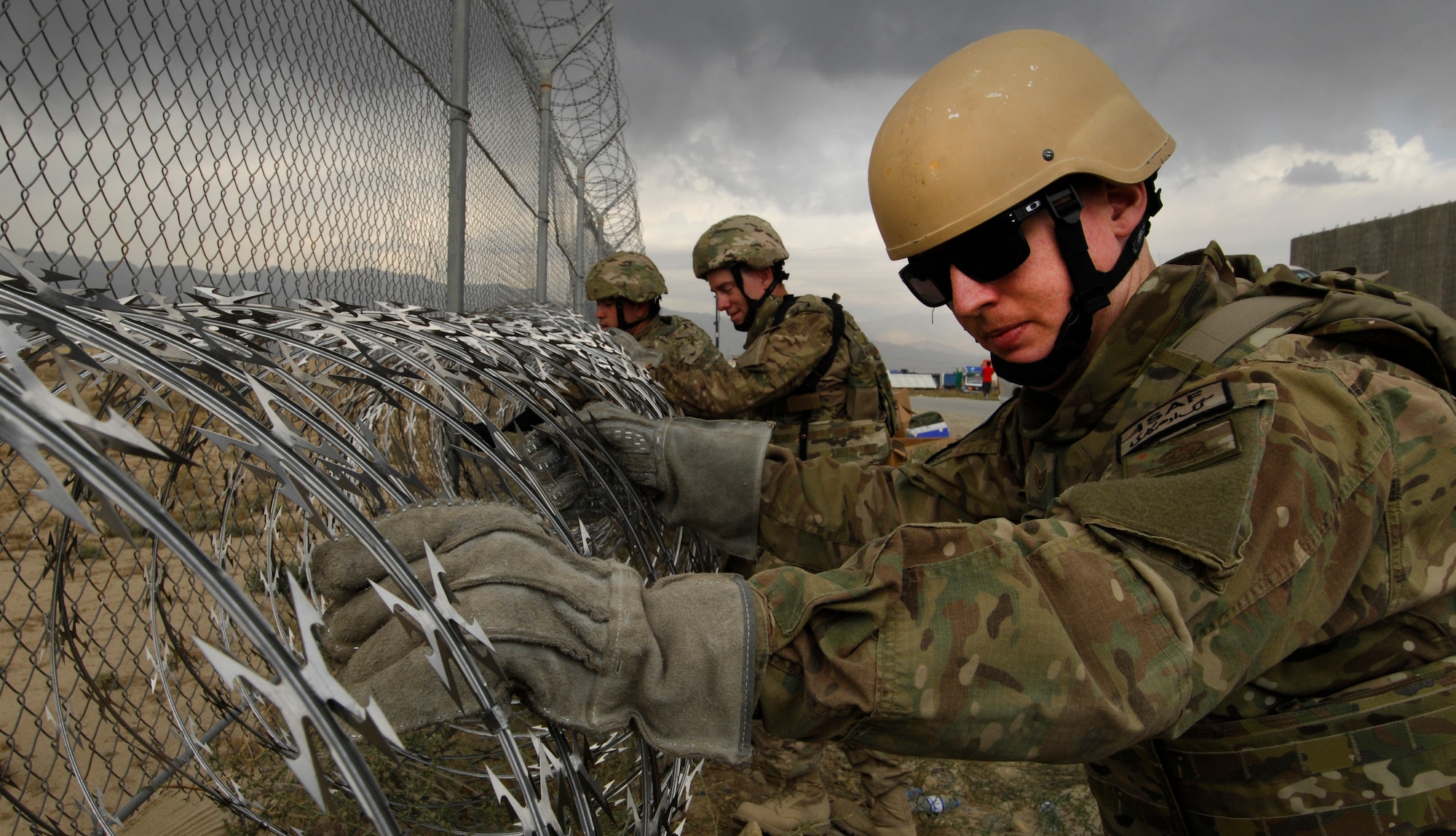 Airmen assigned to the 455th Air Expeditionary Wing put up razor wire along the perimeter of Bagram Airfield Afghanistan, Sept. 26, 2012. For the past two weeks, Bagram Airmen and Soldiers volunteered together, laying razor wire along BAF’s perimeter to enhance base defenses against outside enemy threats. (U.S. Air Force photo/SSgt Jeff Nevison)
