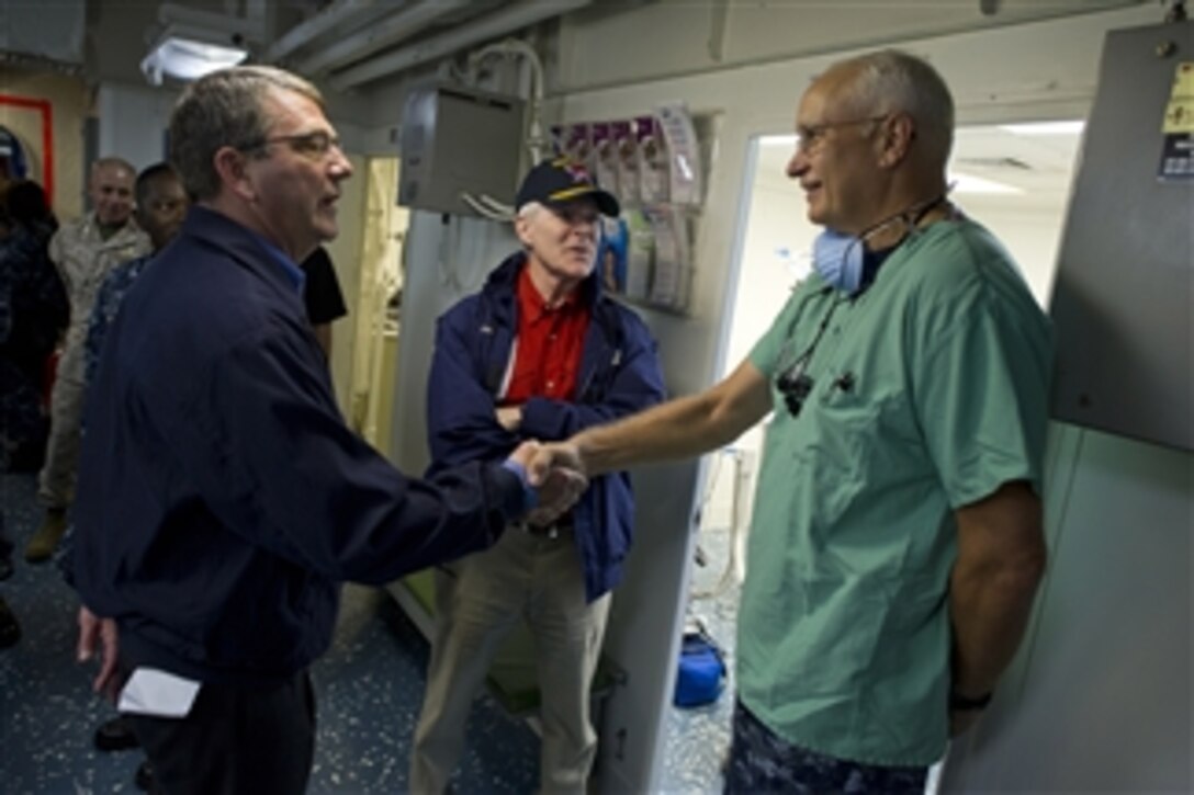 Deputy Secretary of Defense Ashton B. Carter, left, and Secretary of the Navy Ray Mabus, center, greet U.S. Navy Lt. Cmdr. Howard Hall, ship's dentist onboard the amphibious assault ship USS Makin Island (LHD 8), while the ship is moored in San Diego, Calif., on Sept. 27, 2012.  Carter and Mabus visited the USS Makin Island and units stationed at Camp Pendleton during their two-day visit to San Diego.  