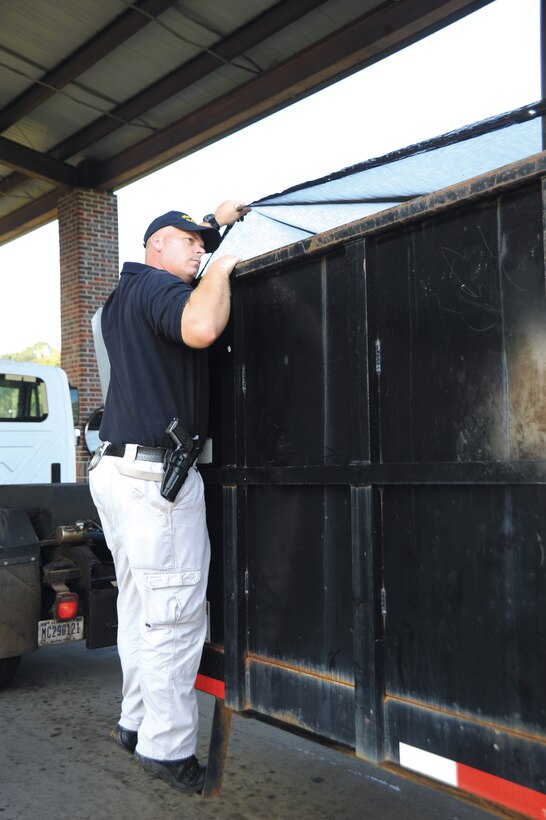 Lt. William Womble Jr., chief accident investigator, Marine Corps Police Department, inspects a garbage truck leaving Marine Corps Logistics Base Albany’s commercial gate, Friday.
