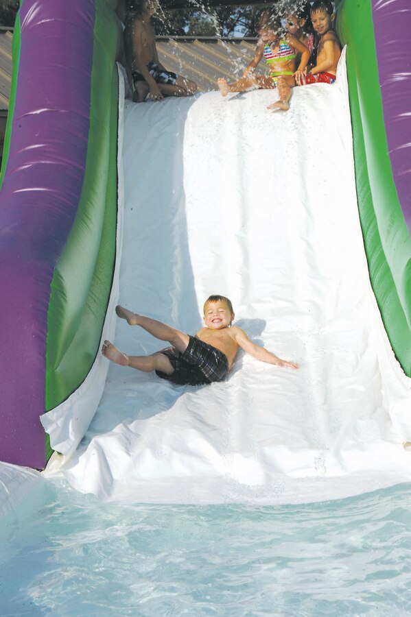 Thane Cotton, 4, cools down on a water slide during a picnic, Friday, near Covella Pond.
