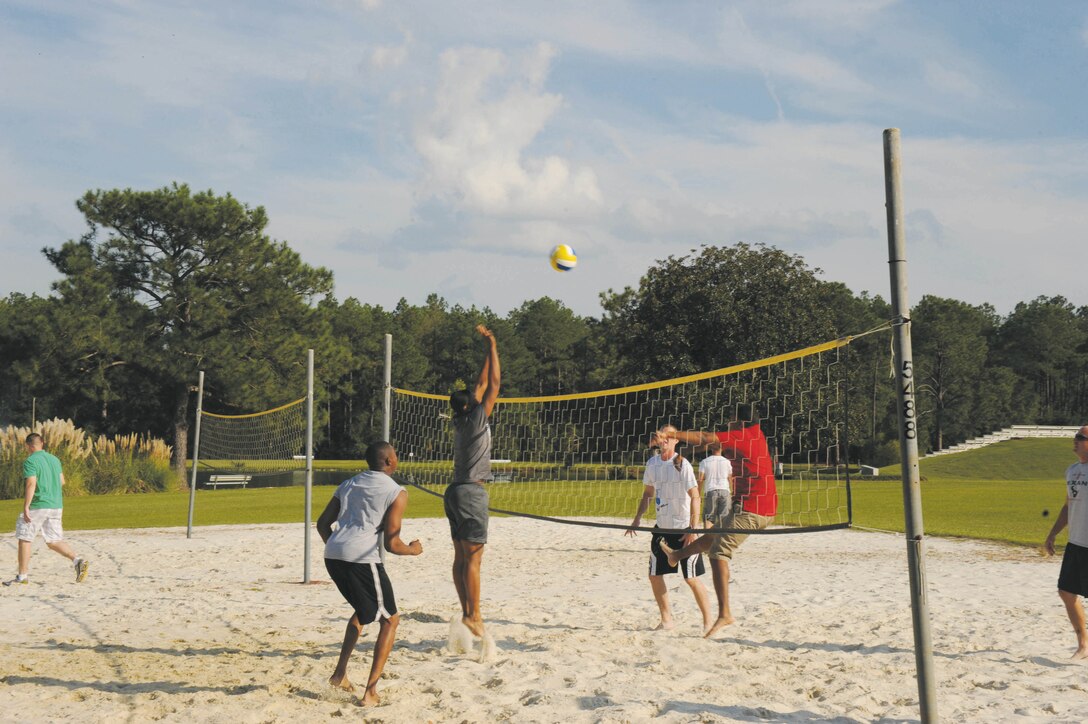 Teams compete against one another in volleyball during a picnic, Friday, near Covella Pond. Hosted by the Marine Corps Logistics Base Albany Family Readiness Officer, activities for the Marines, Sailors and spouses in-cluded feasting on barbecue as well as bouncies for children to play on. 
