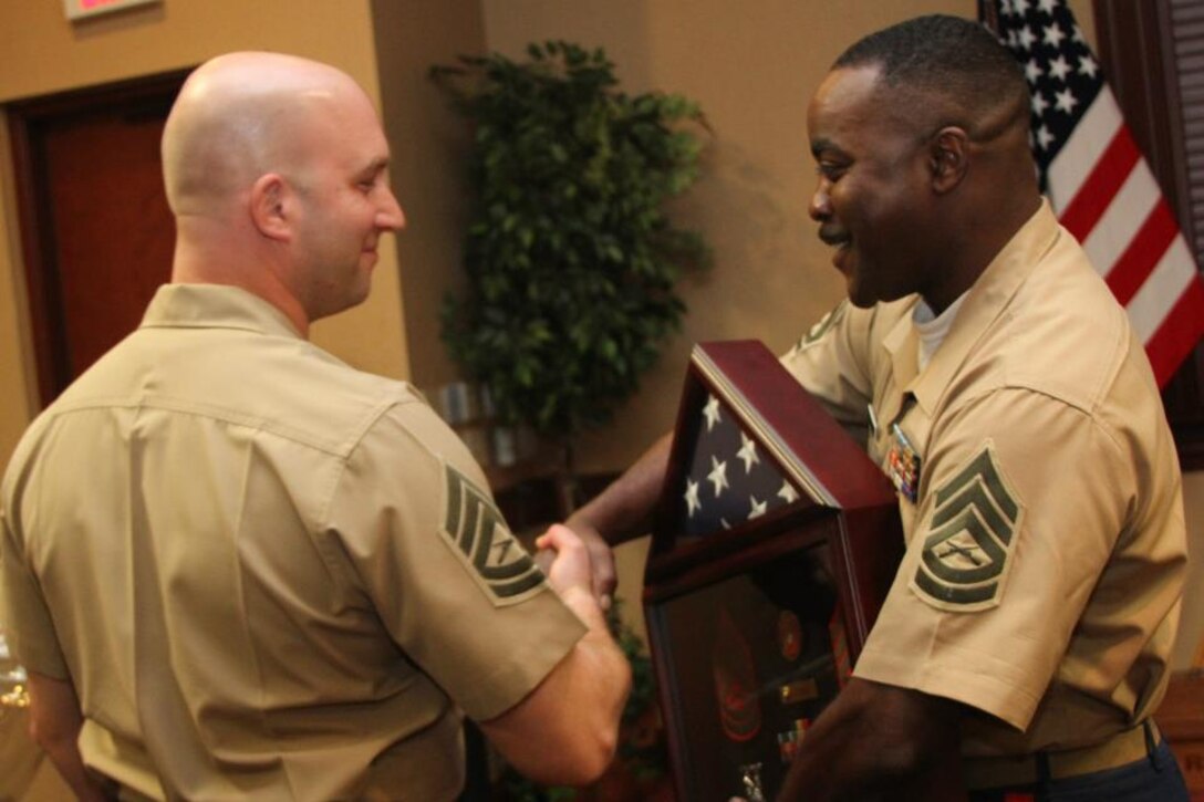 Gunnery Sgt. James C. Smith, III, the staff noncommissioned officer-in-charge of Recruiting Substation Asheville, Recruiting Station Columbia, presents a gift to Gunnery Sgt. David Celej, the former SNCOIC of RSS Asheville, Sept. 28 following Celej's retirement ceremony. Celej retired following 20 years of service.