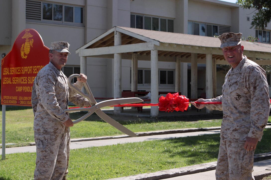Brig. Gen. Vincent A. Coglianese, the commanding general of Marine Corps Base Camp Pendleton and Marine Corps Installations-West, and Brig. Gen. John J. Broadmeadow, commanding general of 1st Marine Logistics Group aboard MCB Camp Pendleton, pose during the ribbon-cutting ceremony that symbolized the consolidation of Legal Services Support Team Marine Corps Base Camp Pendleton and Legal Service Support Section-West, here Oct. 1.
