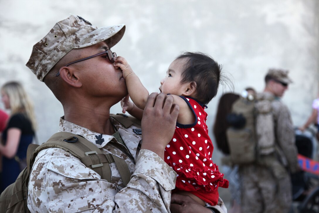 Petty Officer 1st Class Aristotle Tuvera, Hospital Corpsman, 1st Battalion, 7th Marine Regiment, meets his daughter Aisis, 6 months, for the first time during a 1/7 homecoming event Sept. 15 at Del Valle Field.